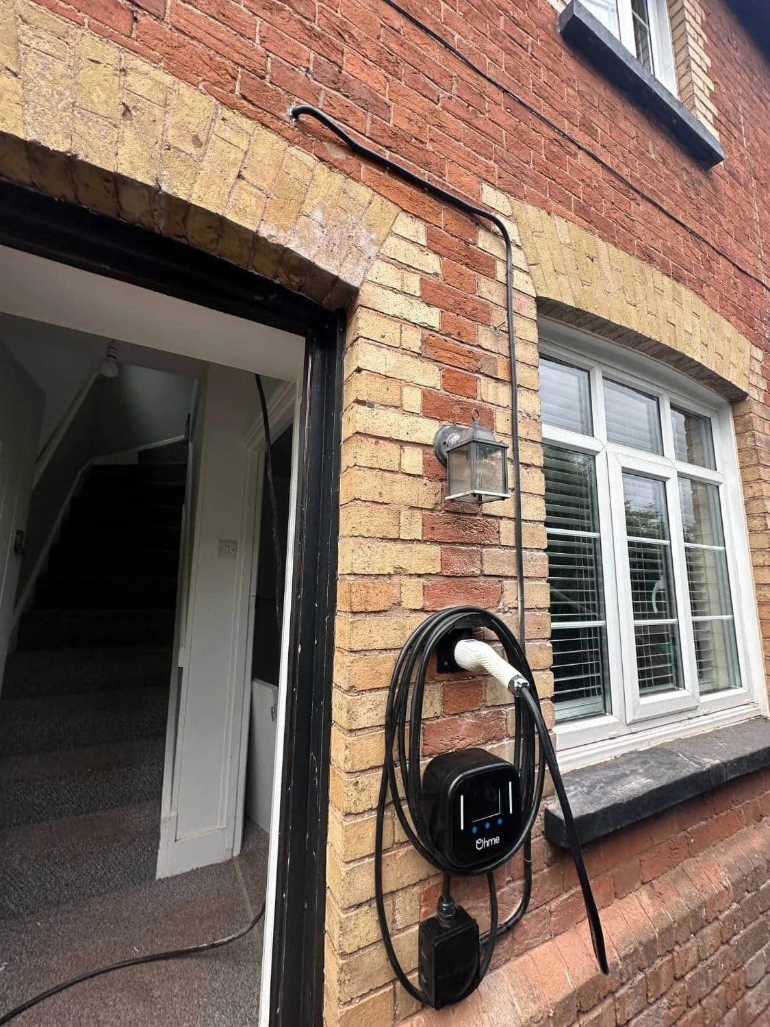 Photo taken of an external wall near a front door after an EV charger has been installed.