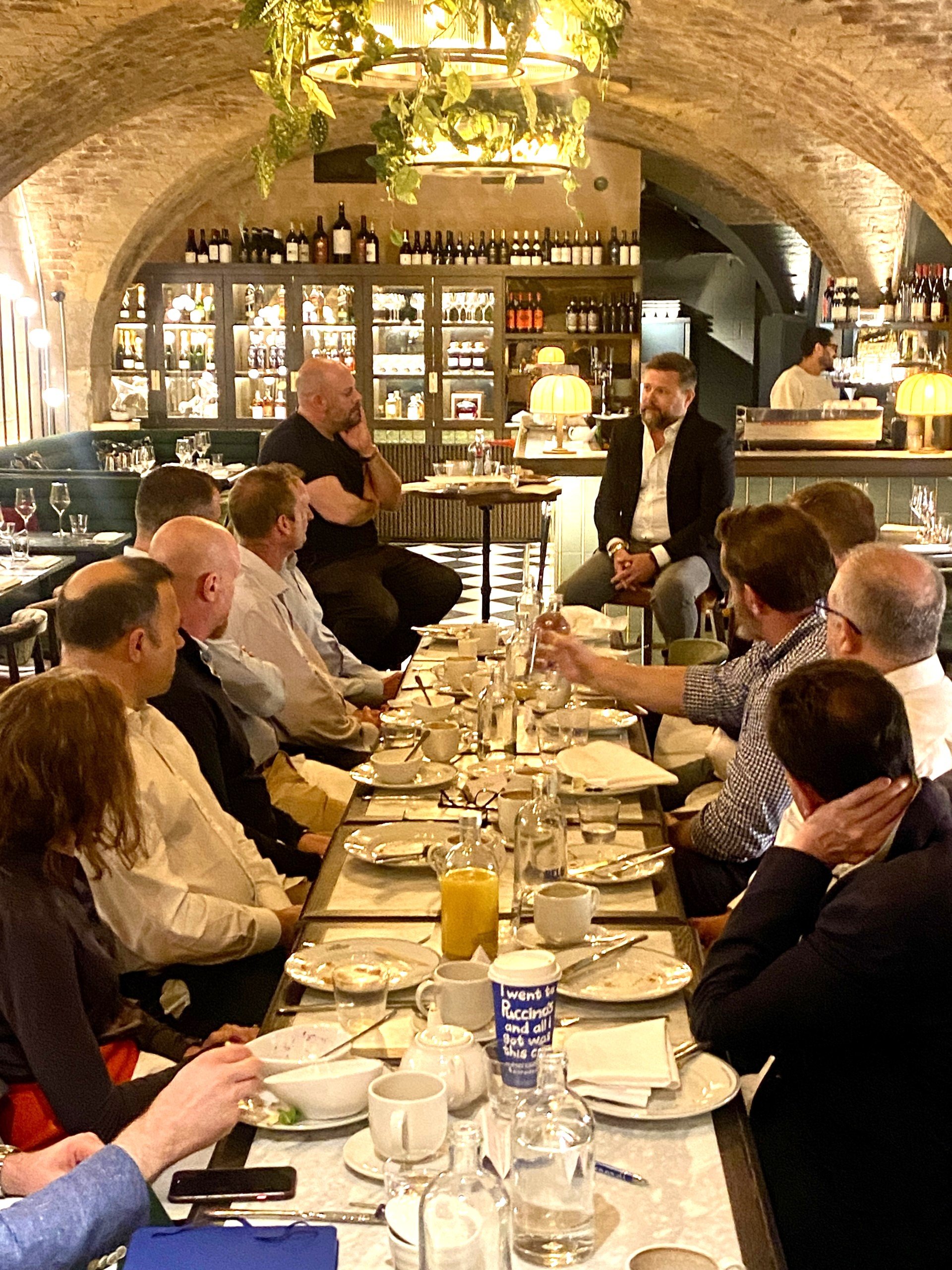 Attendees captivated by speaker around a table at Hacked event
