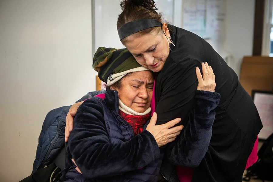 Two people hugging in support—community care, healing, and belonging.