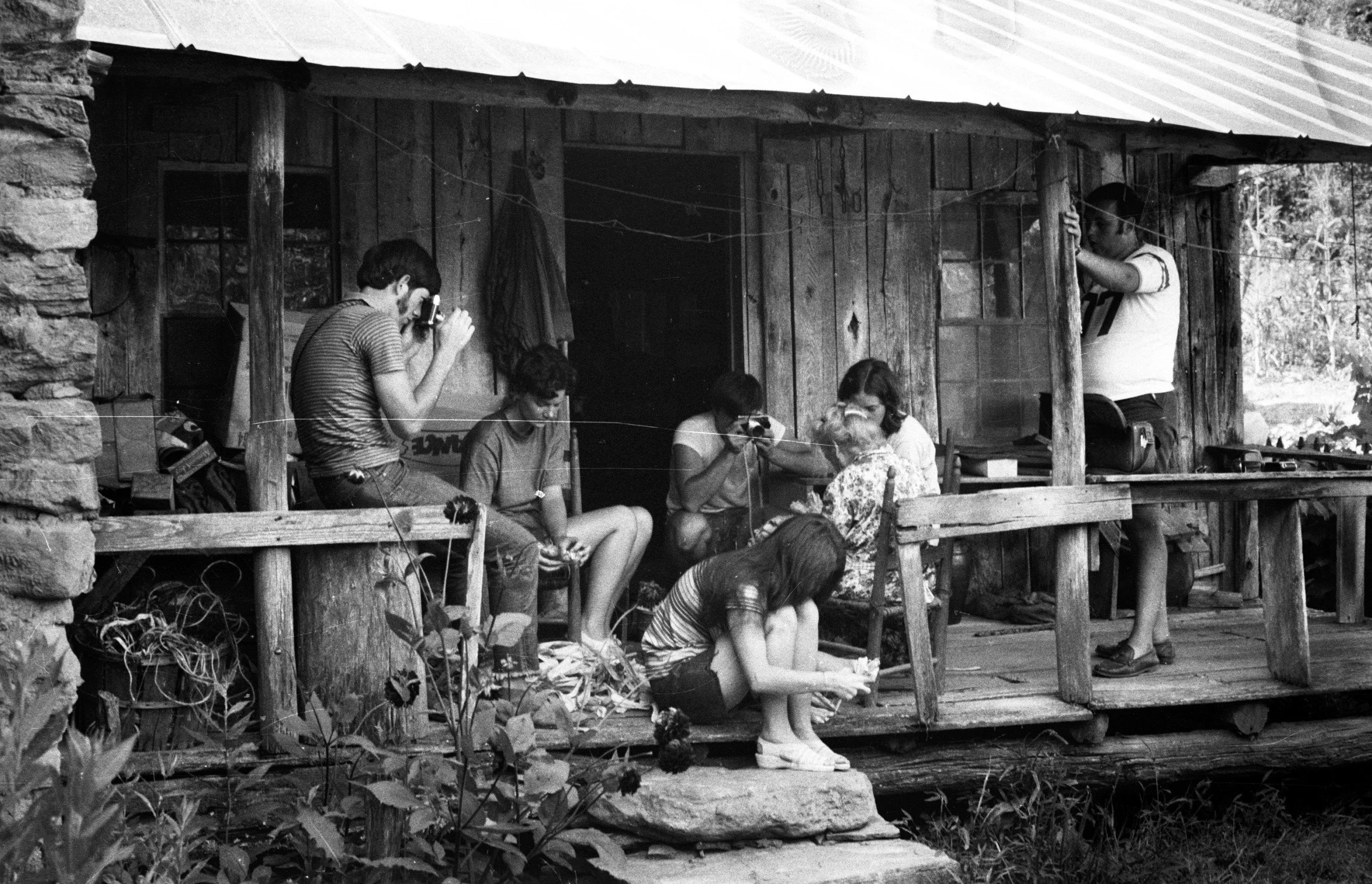People relaxing on a rustic cabin porch—community culture, storytelling, and place-based connection