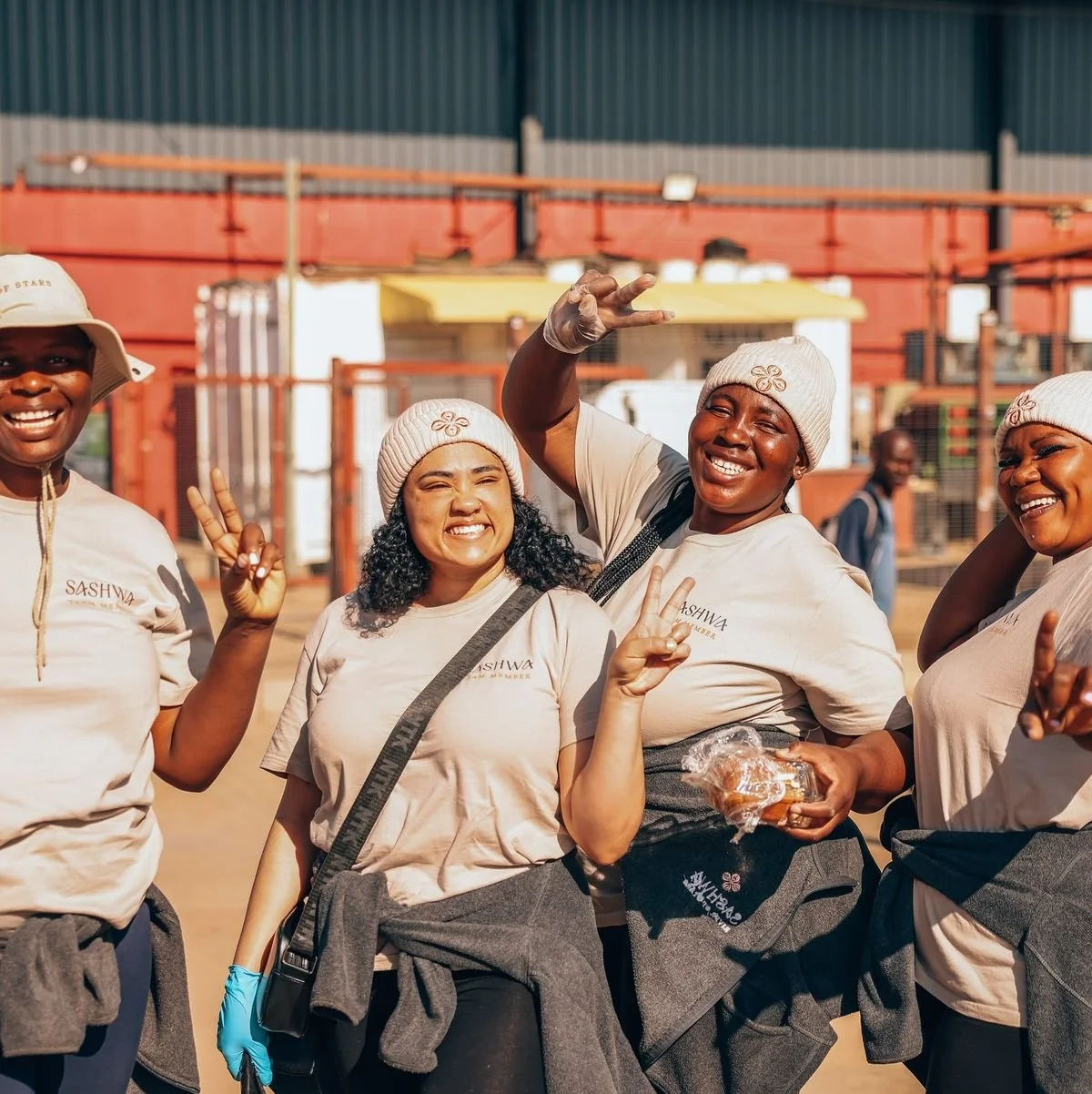Smiling women posing outdoors with baked goods—community entrepreneurship and mutual support.