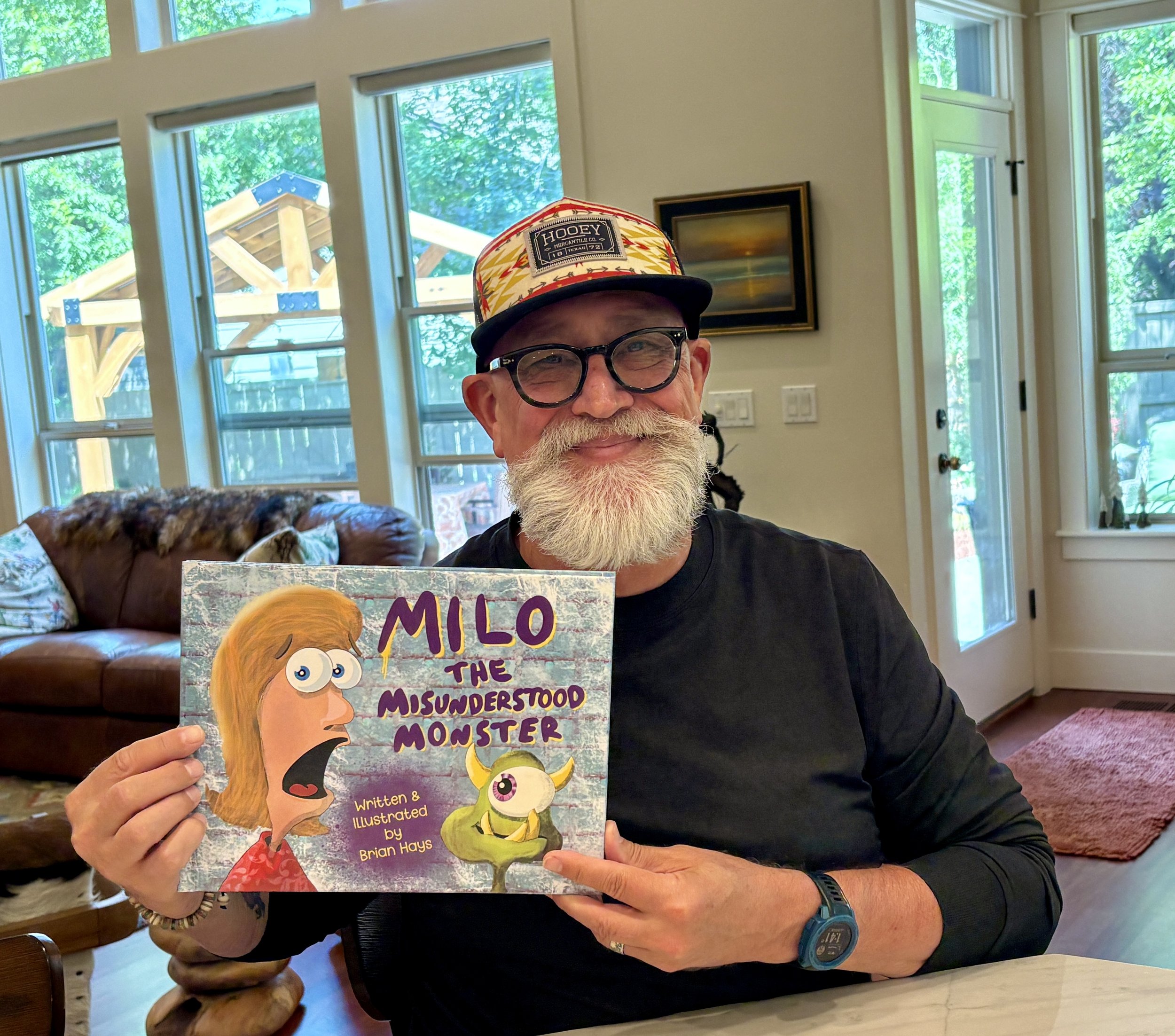 Brian Hays, children's book author/illustrator holding his book titled, "Milo The Misunderstood Monster".