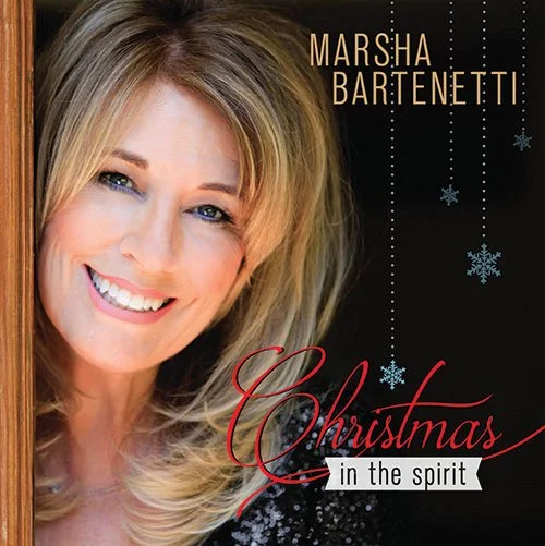 Album cover for 'Christmas in The Spirit' by Marsha Bartenetti against a dark background.