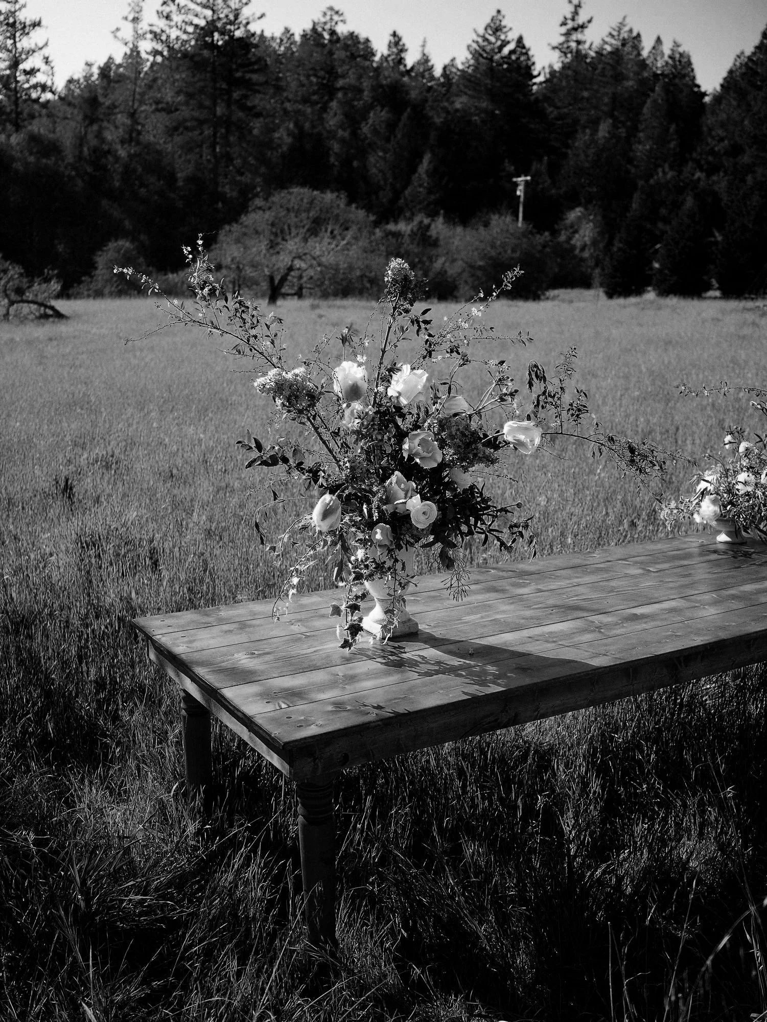 Whimsical garden florals sitting on a rustic wood table in the middle of a flower farm field.