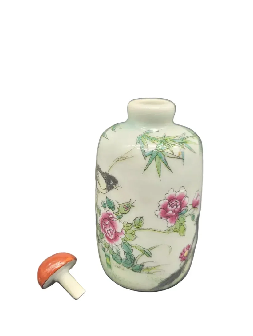 Chinese antique snuff bottle is crafted from fine Famille Rose porcelain, showcasing the delicate artistry and vibrant palette characteristic of the period.