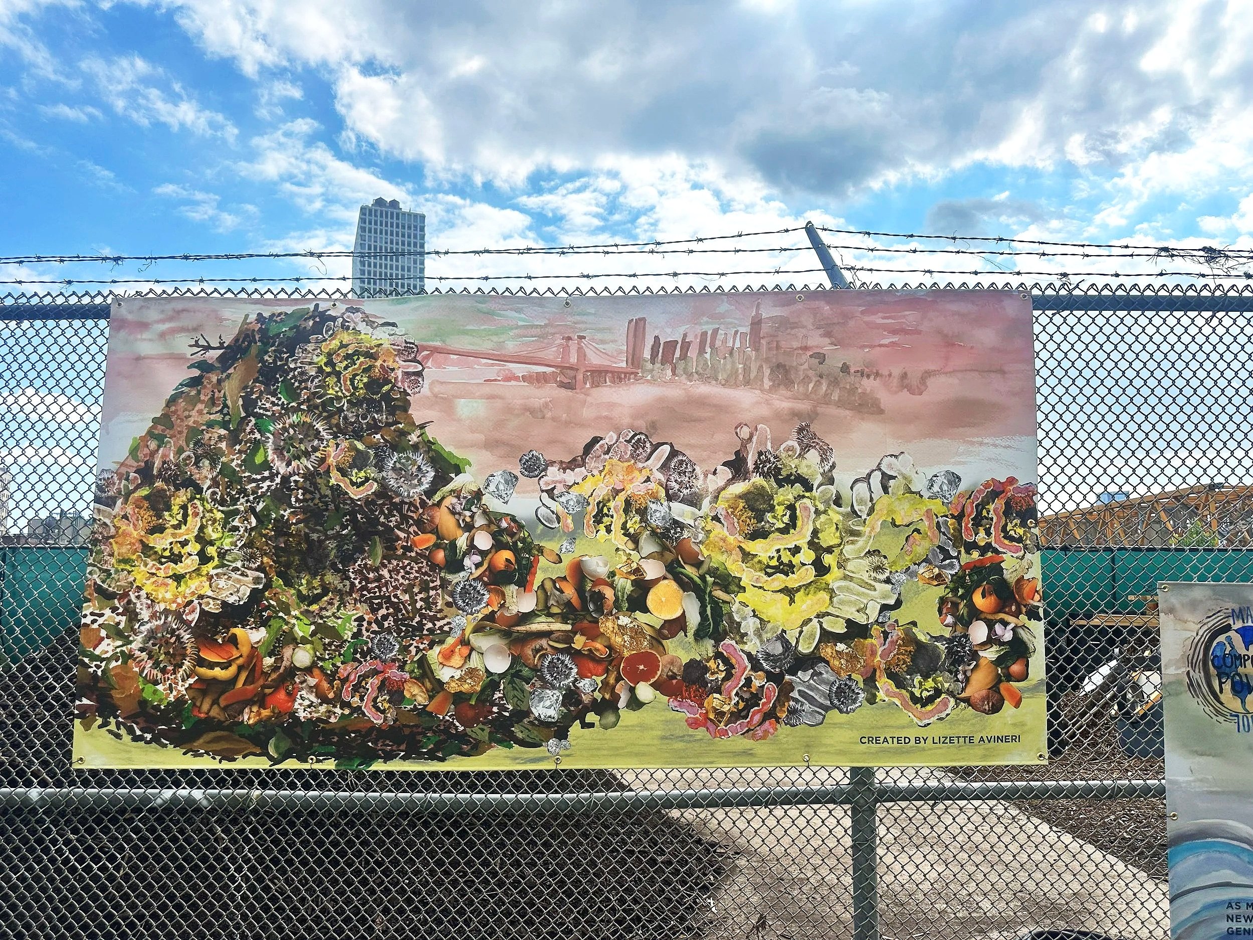 A painted mural on a fence showing an abstract landscape with trees, a river, and the New York City skyline with a bridge and tall buildings in the background, created by Lizette Avineri.