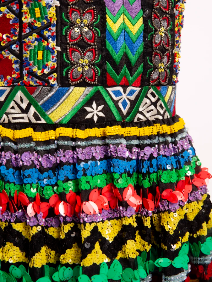 Close-up of a colorful, beaded, and sequined traditional dress with intricate patterns and vibrant colors.