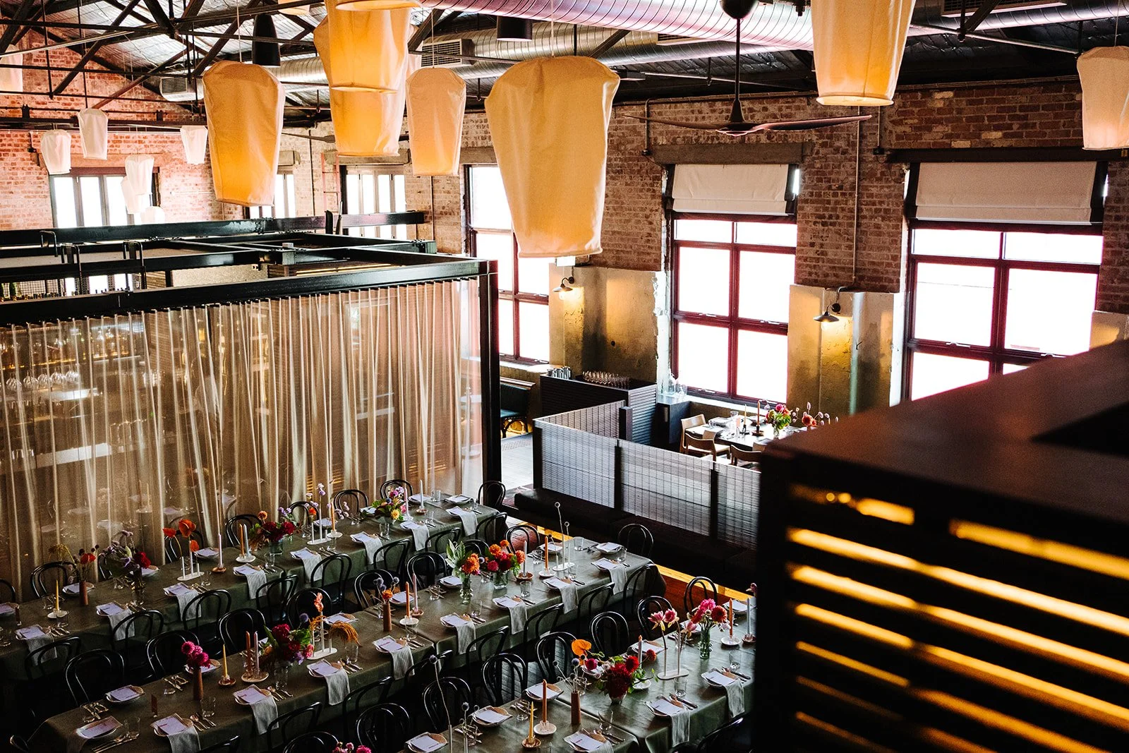 Longsong decorated for an event with long tables set with white napkins, glassware, and floral centerpieces. 