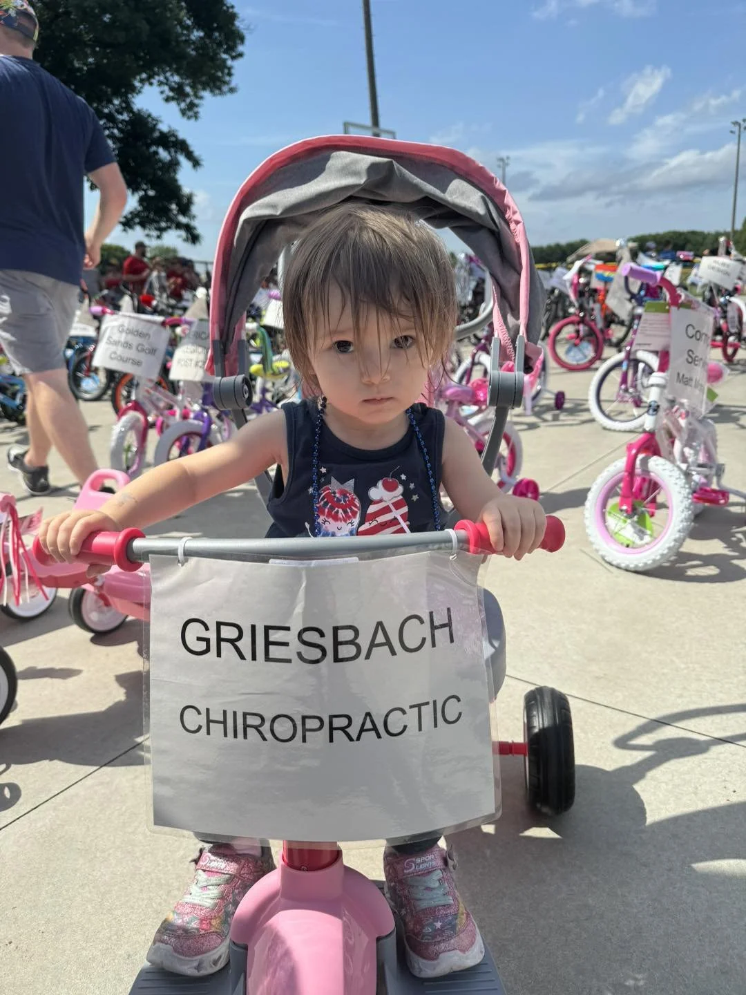 Young child sitting on a bicycle donated by Griesbach Chiropractic at the 4th of July raffle