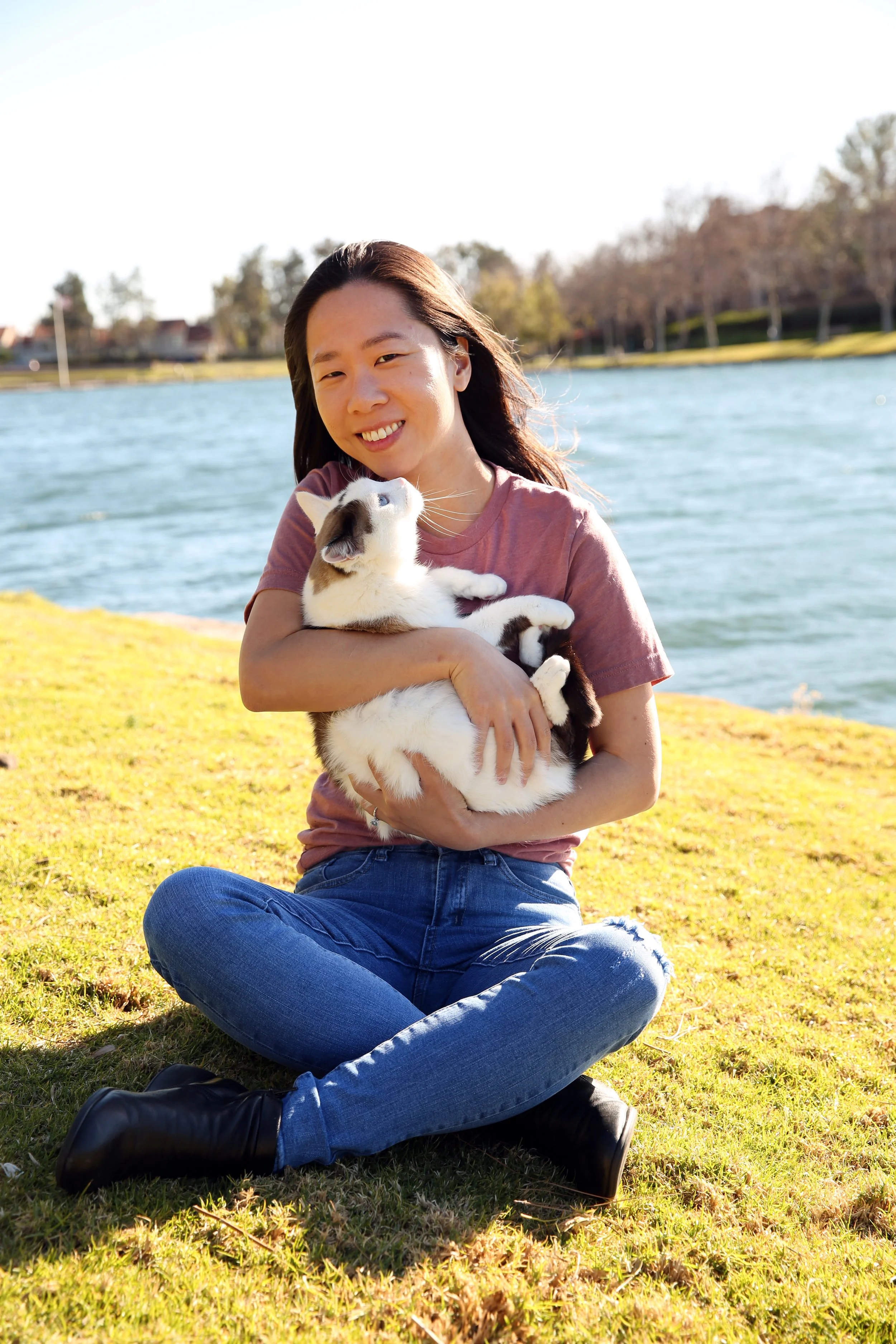 Terri holding her cat, Mashi, on a sunny day