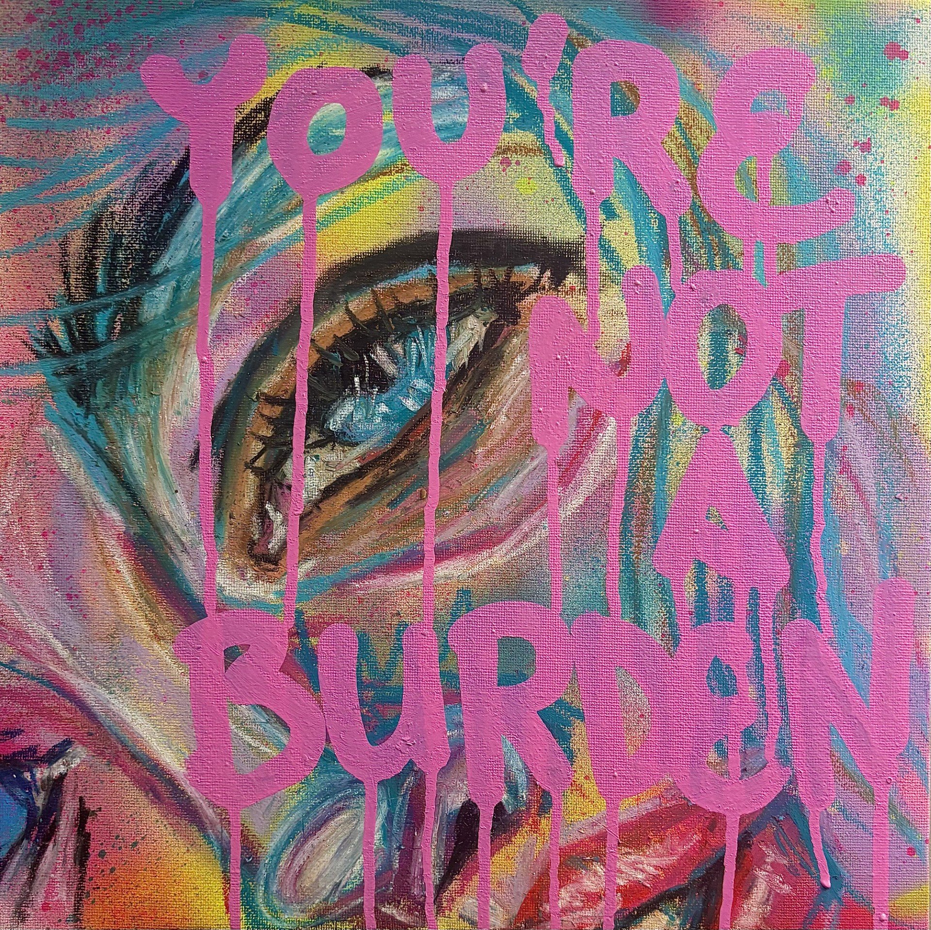 A colorful painting of a woman's eye with pink spray-painted text reading 'You're Not Your Burnout' over it.