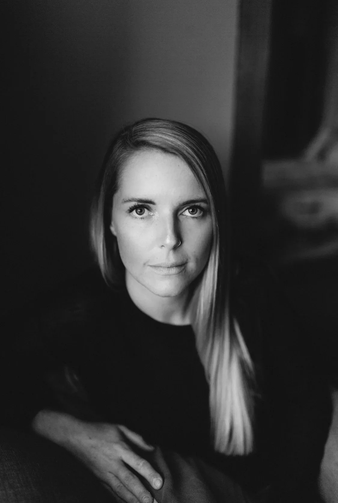 Black and white portrait of a woman with long, straight hair, looking directly at the camera.