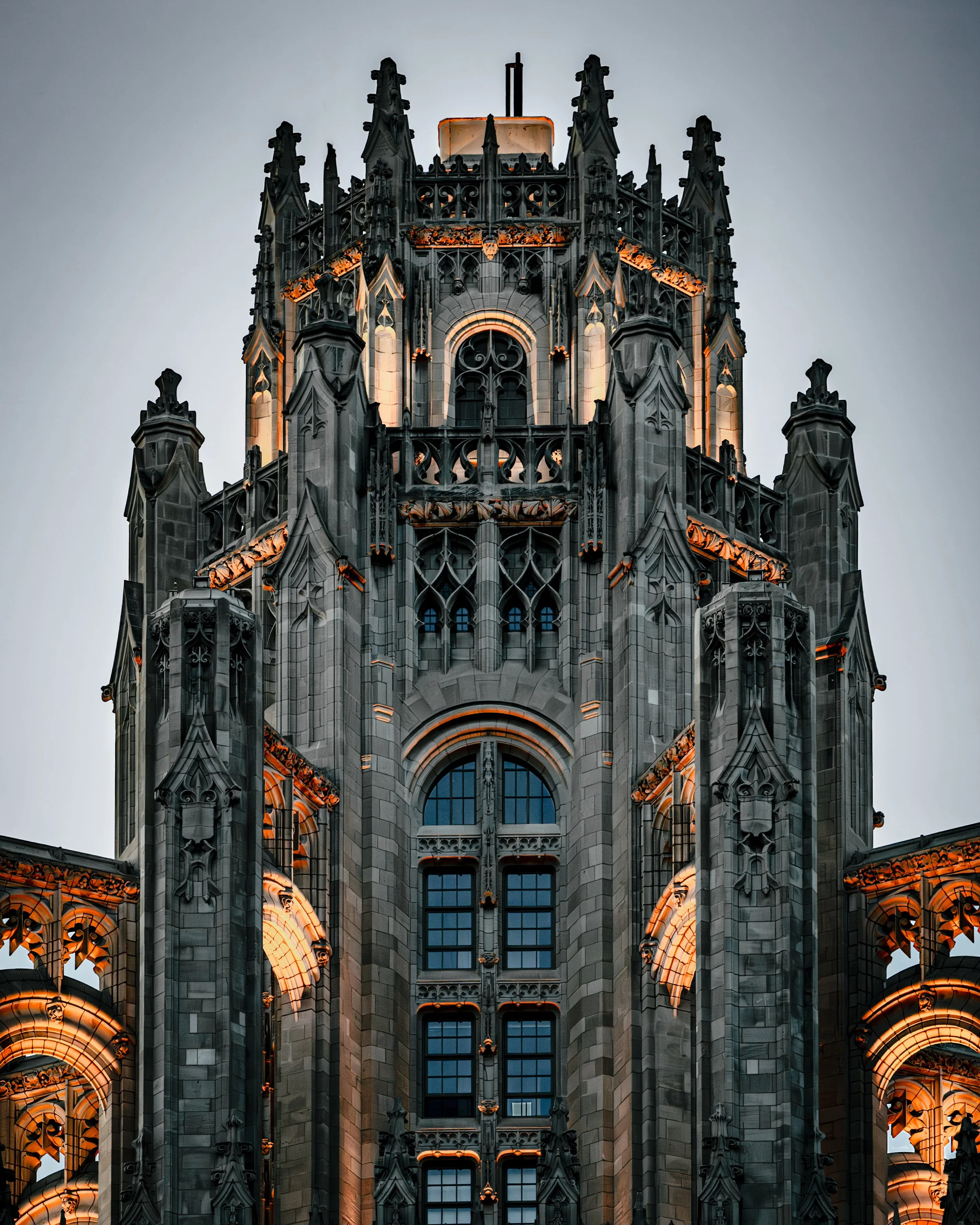 Nighttime view of a Gothic-style cathedral with ornate stonework and illuminated windows.