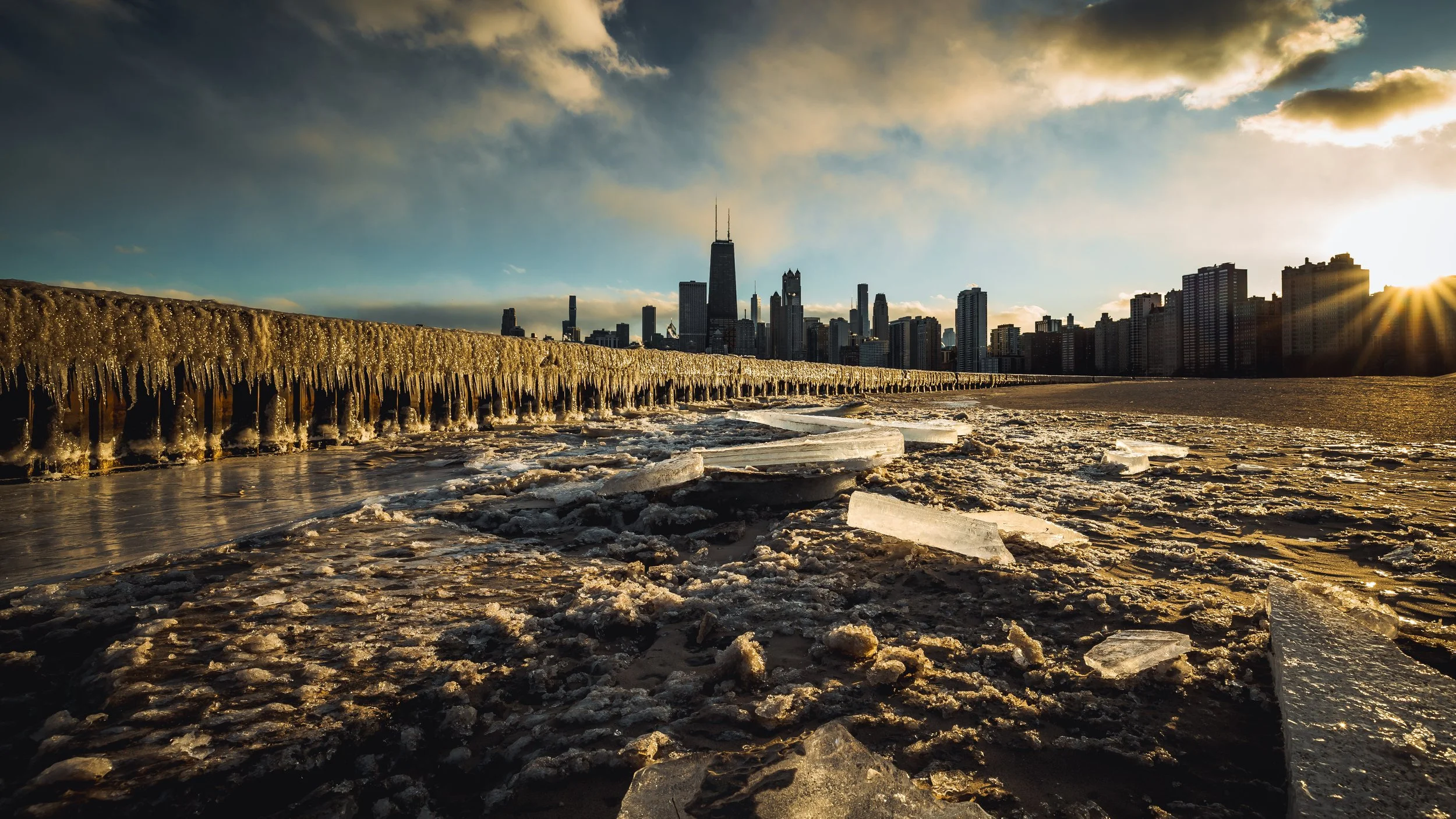 Chicago skyline at sunset with frozen shoreline and ice chunks in the foreground
