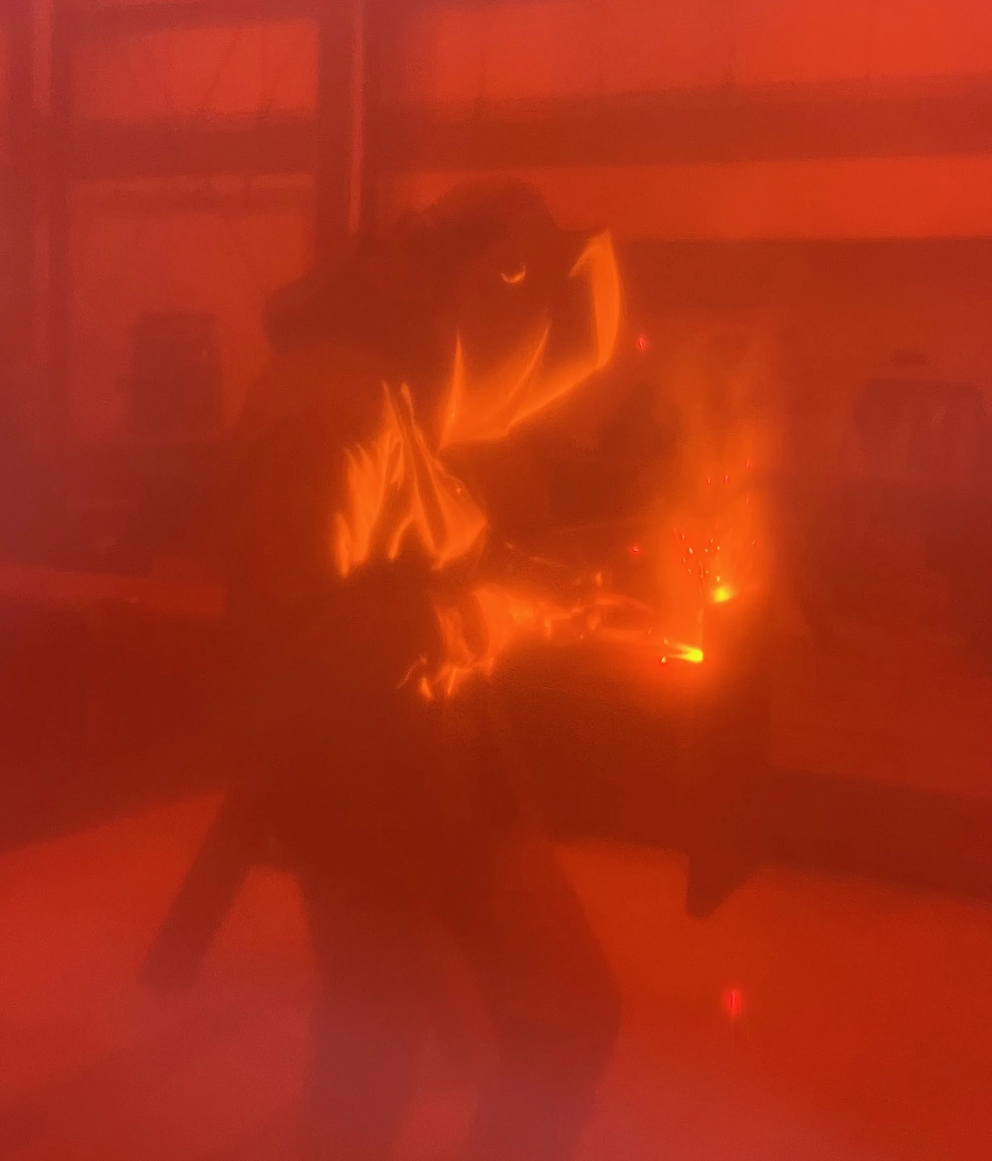 welder behind red screen