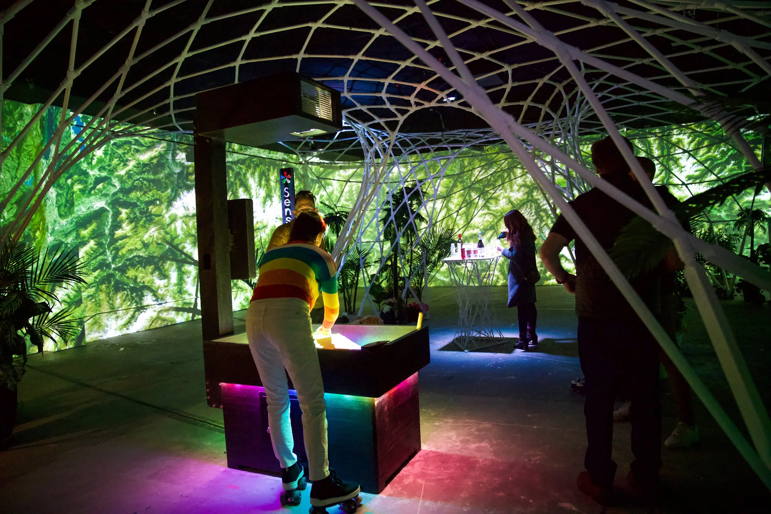 Guest at an interactive light table inside the ILLUMIBRATE 2025 pavilion in Boise, Idaho, on roller skates in rainbow.