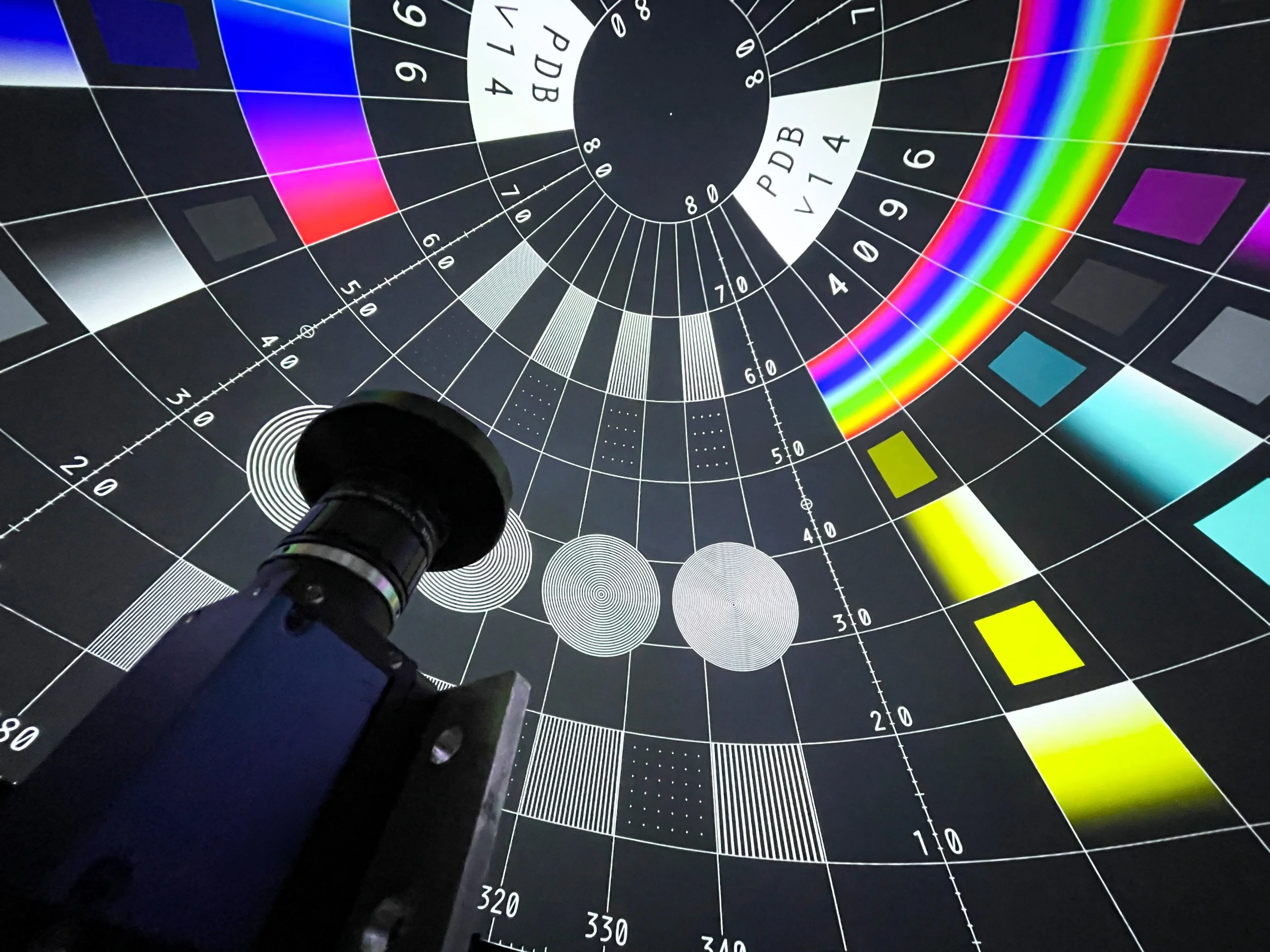 Calibration camera with fisheye lens inside a Hollywood projection dome aimed at a test pattern with zone plate targets