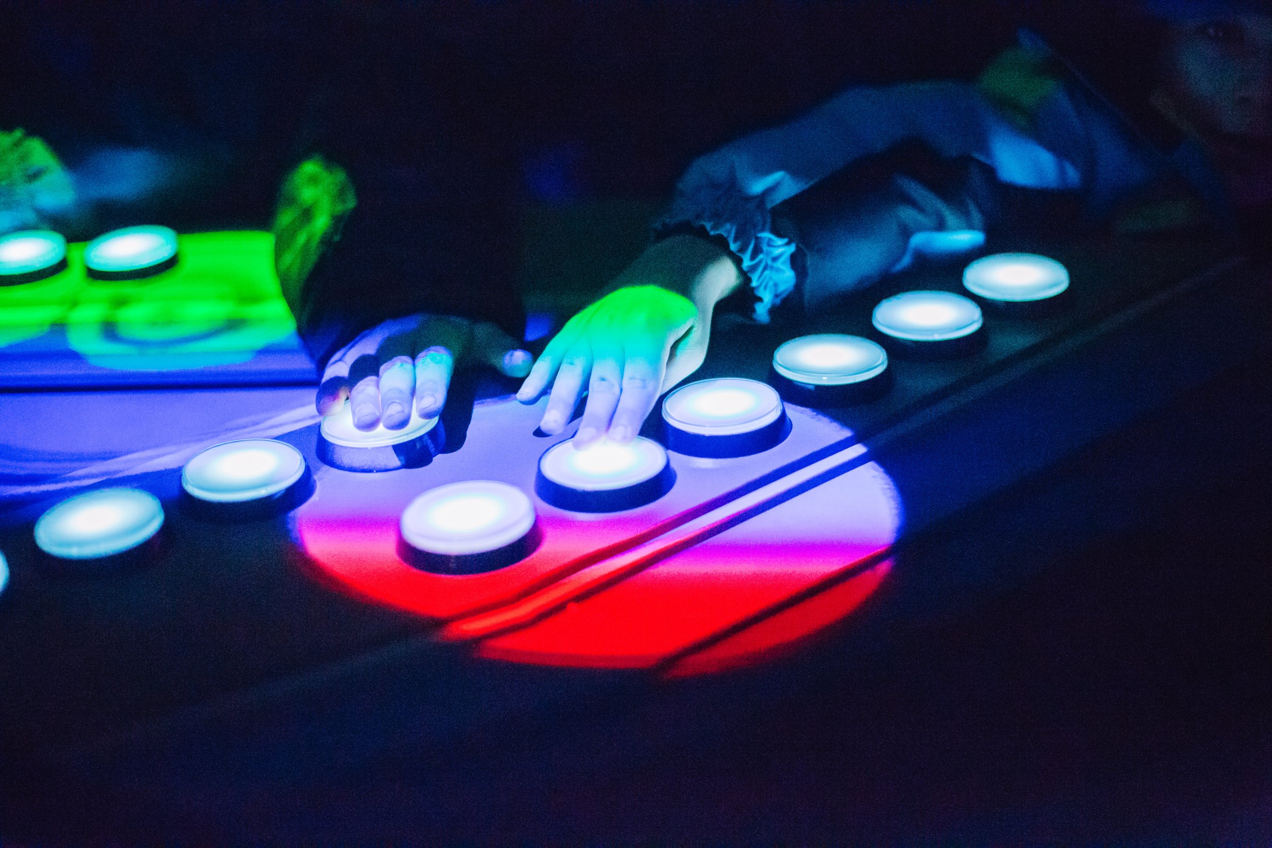 SAM Lights 2017 at Seattle Olympic Sculpture Park, hands on glowing arcade buttons over the lit park map
