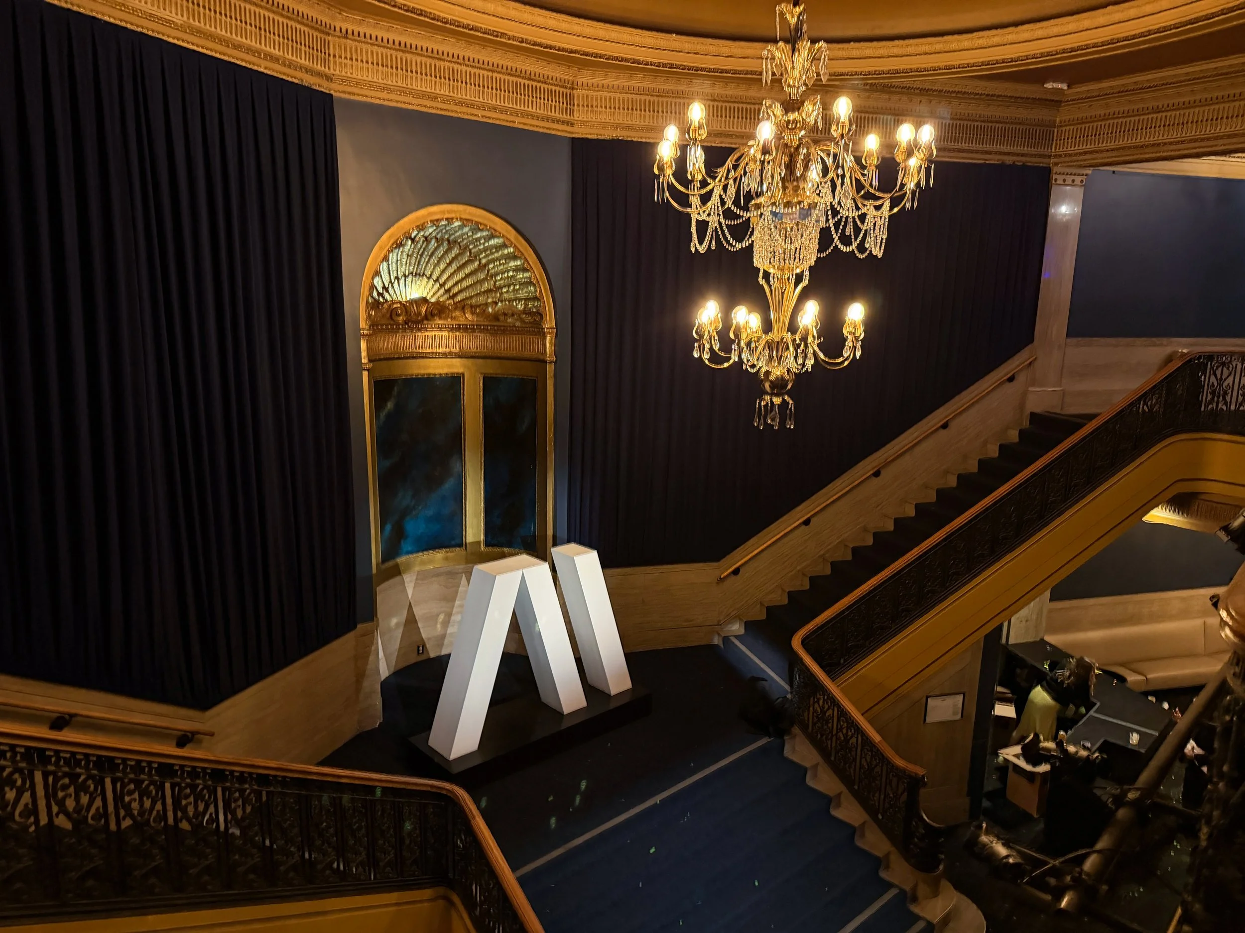 Bare 3D logo sculpture on the Warfield balcony landing in San Francisco before projection mapping, house lights on.