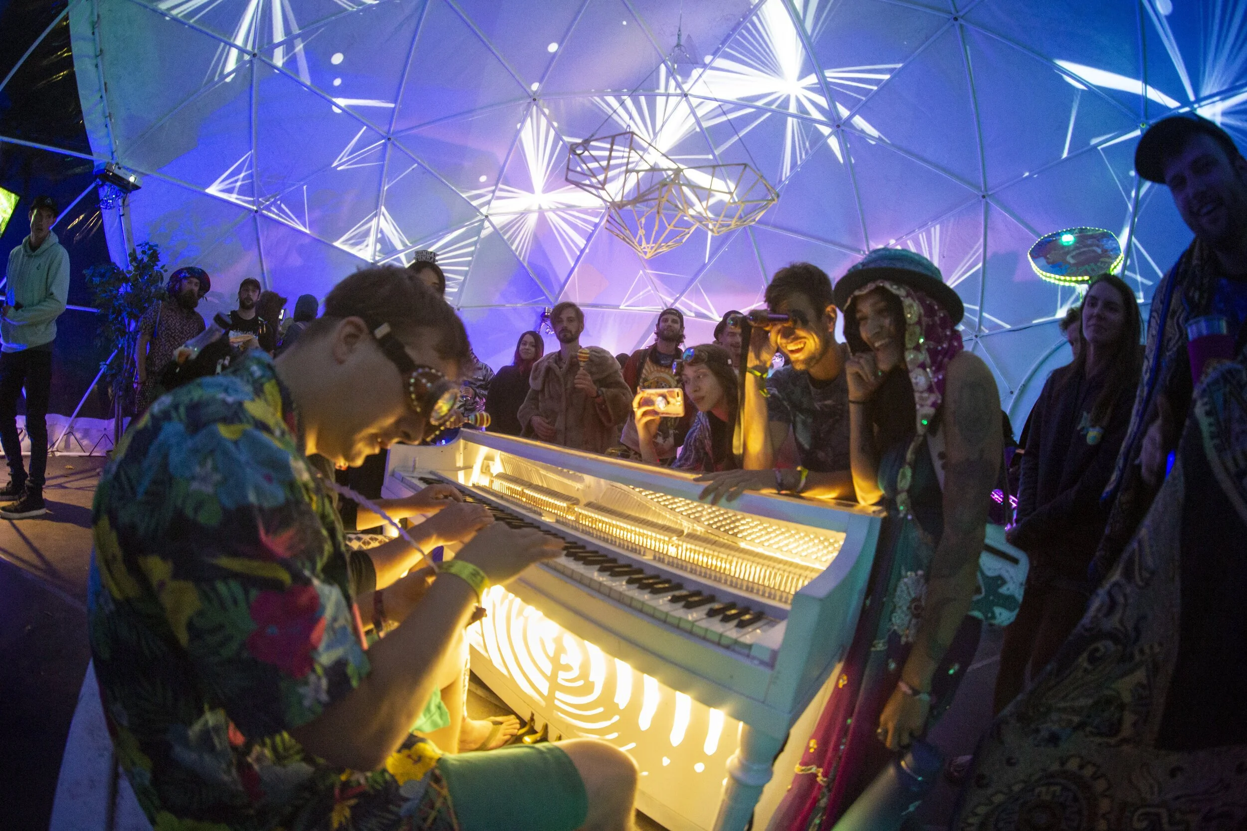 Light up piano inside the Sensatorium dome at Summer Meltdown, Darrington, Washington, guests crowded around to watch.