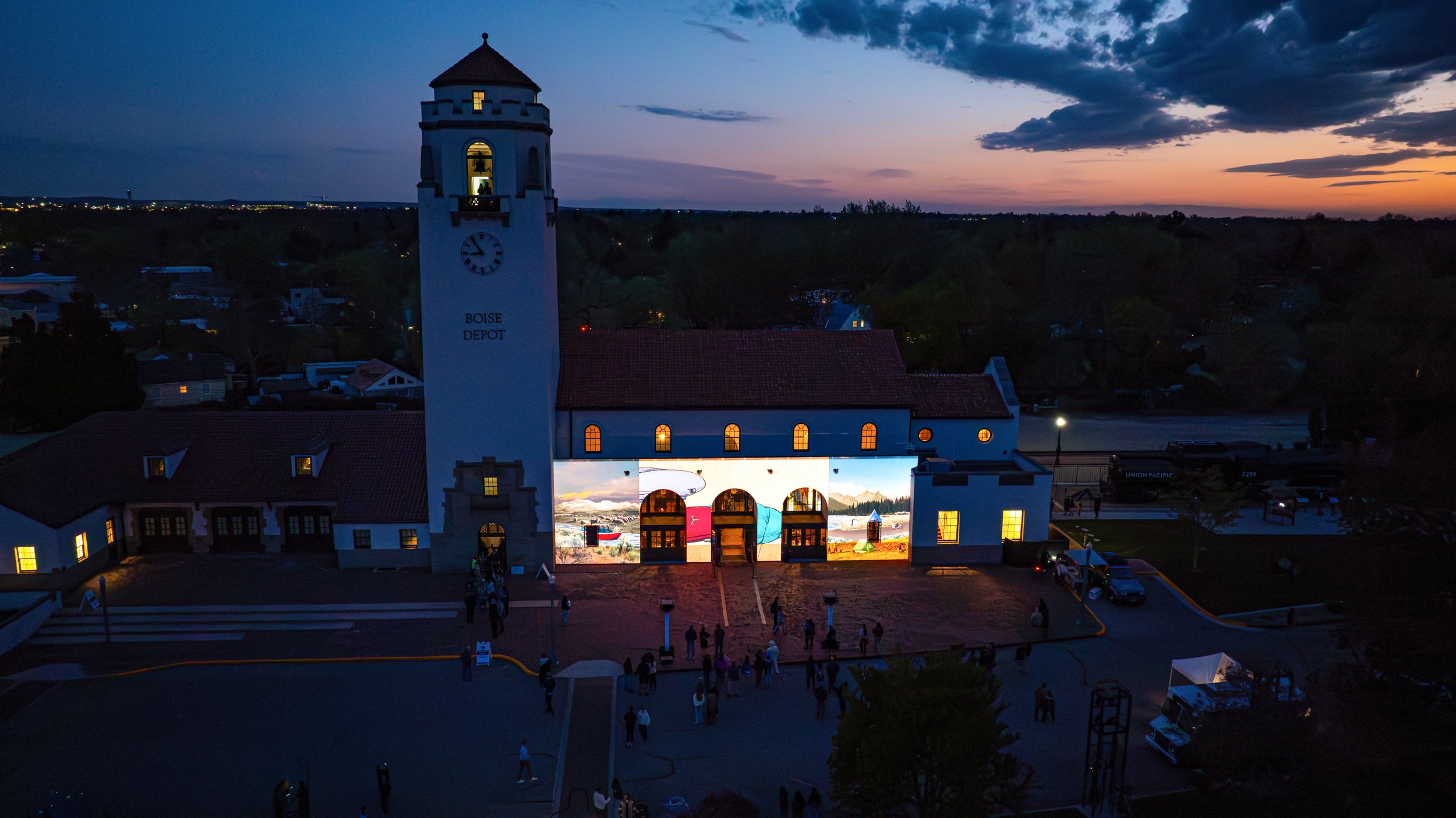 Boise Depot 100th anniversary projection mapping, aerial dusk view of lit facade and gathered crowd