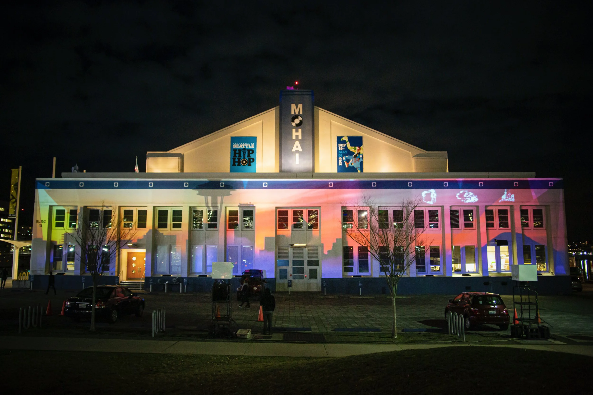 Microsoft at MOHAI projection mapping in Seattle, full front facade lit with sunset visuals at night.