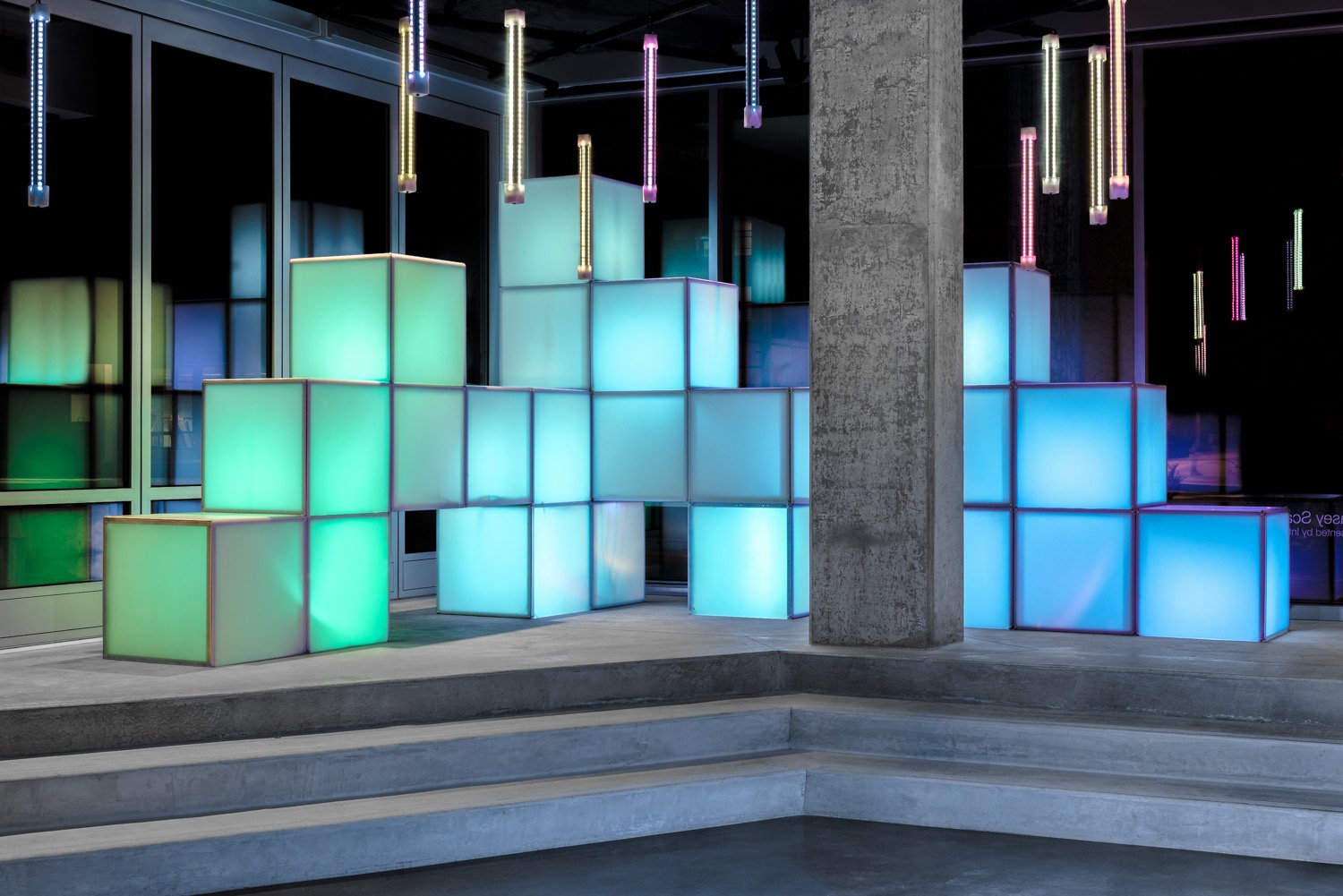 CUBIX cubes lighting installation, a glowing stacked cube array with hanging tube bars above steps