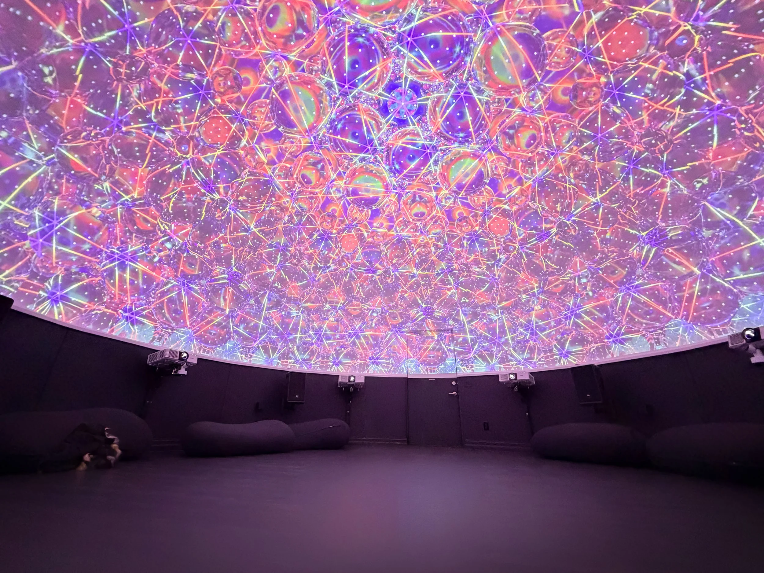 Dome projection mapping in a full ceiling of glowing sacred geometry above an empty studio floor