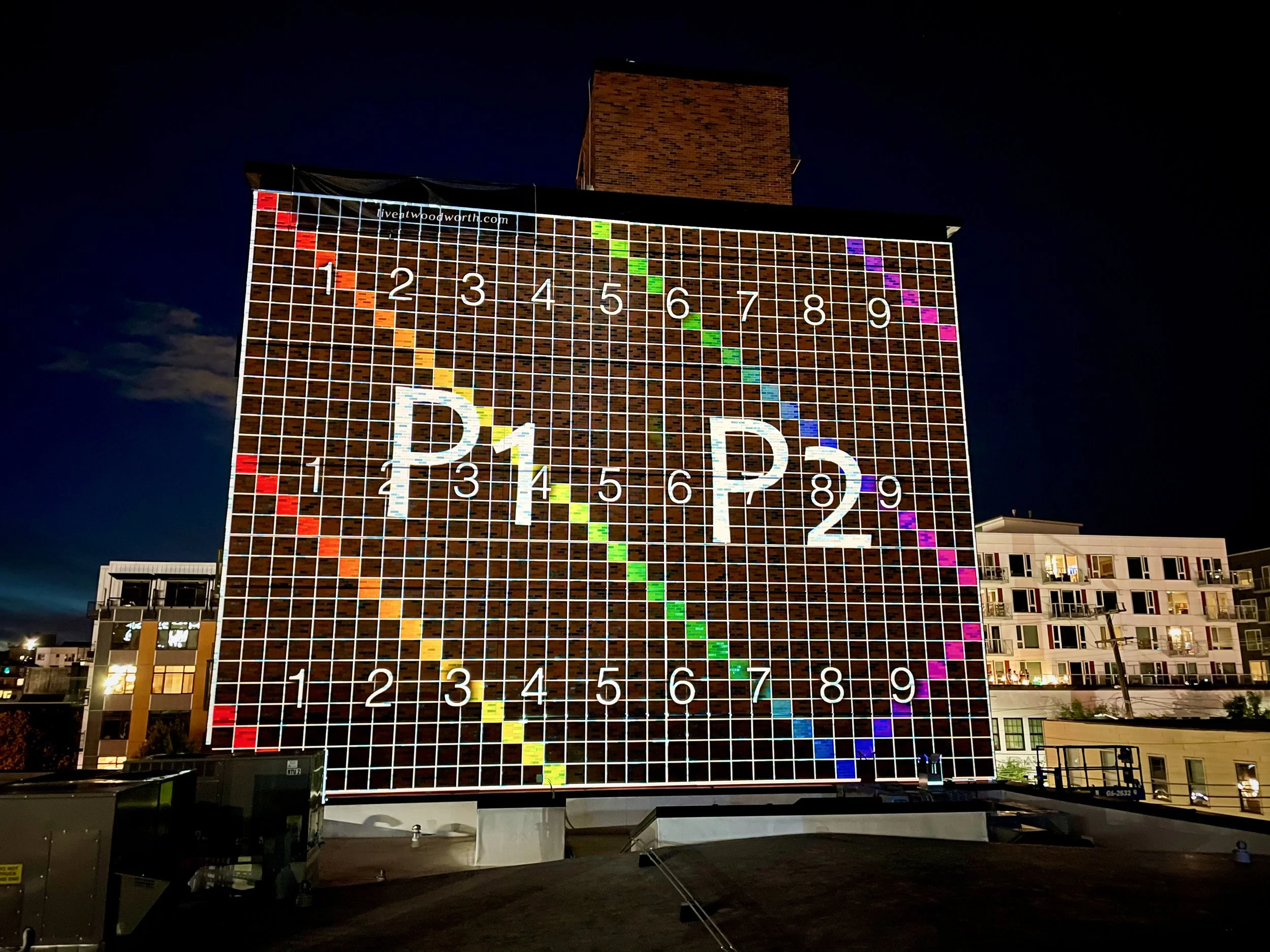 Woodworth Apartments projection mapping, Capitol Hill Seattle, dual projector calibration grid mapped across the wall.