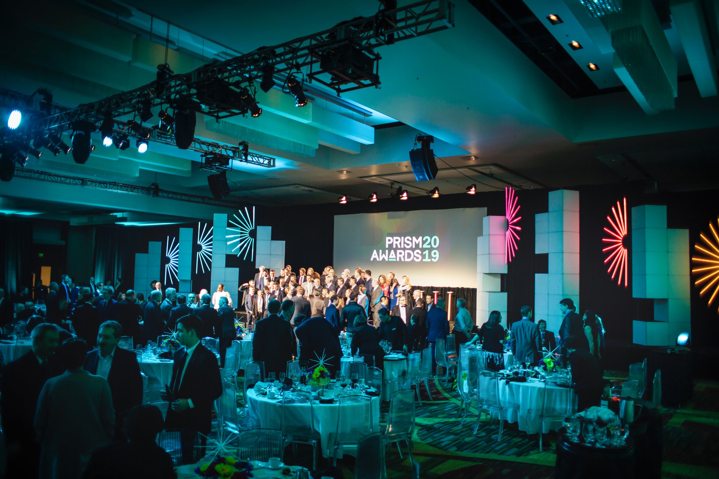 SPIE PRISM Awards projection mapping at Photonics West, crowd gathered before the stage under teal light