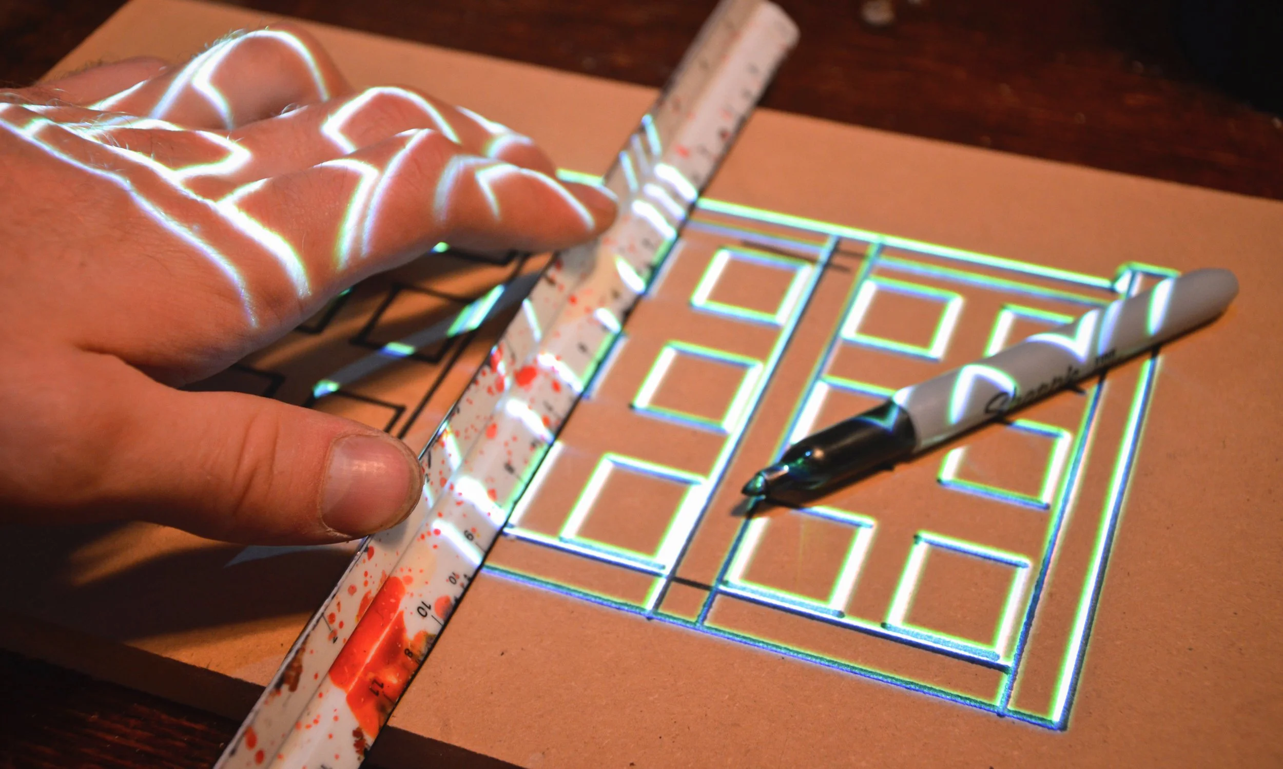 Freaknight Music Festival projection mapping design, green outlines tested on cardboard with ruler and marker