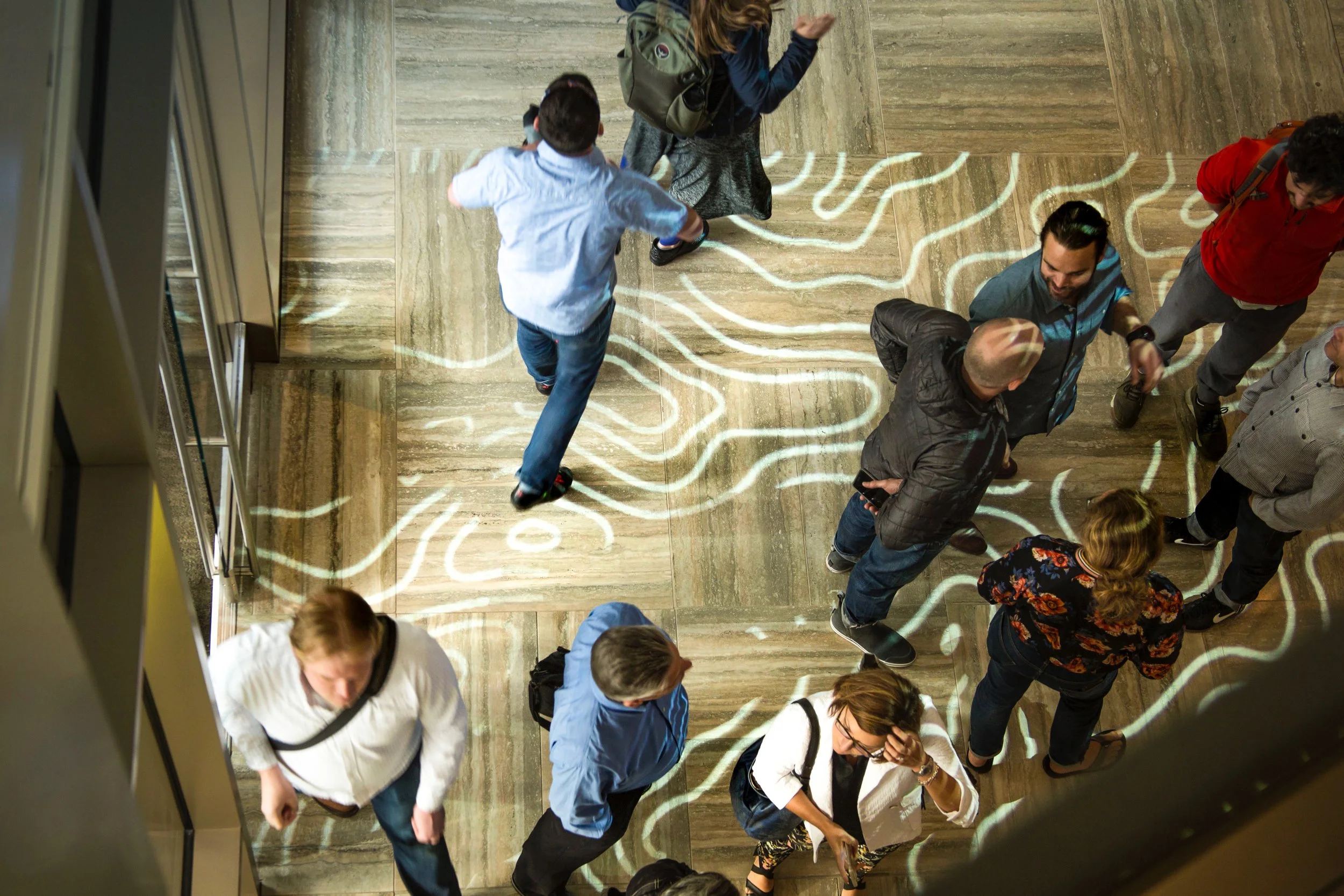Projection mapping of topographic lines on the lobby floor at The Collective grand opening in Seattle, Washington