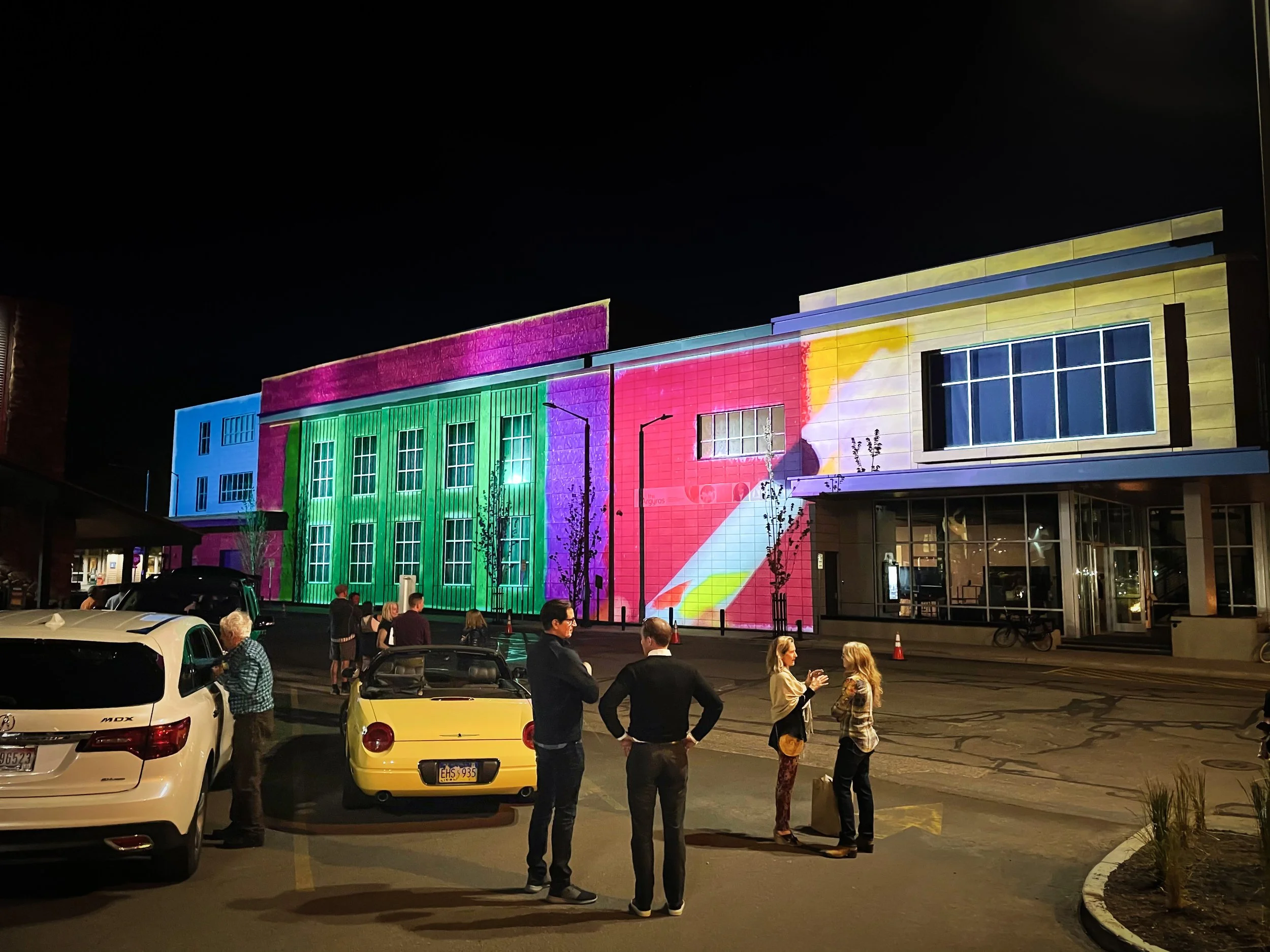 The Argyros projection mapping in Ketchum, Idaho, crowd watches the lit facade from Main Street at dusk