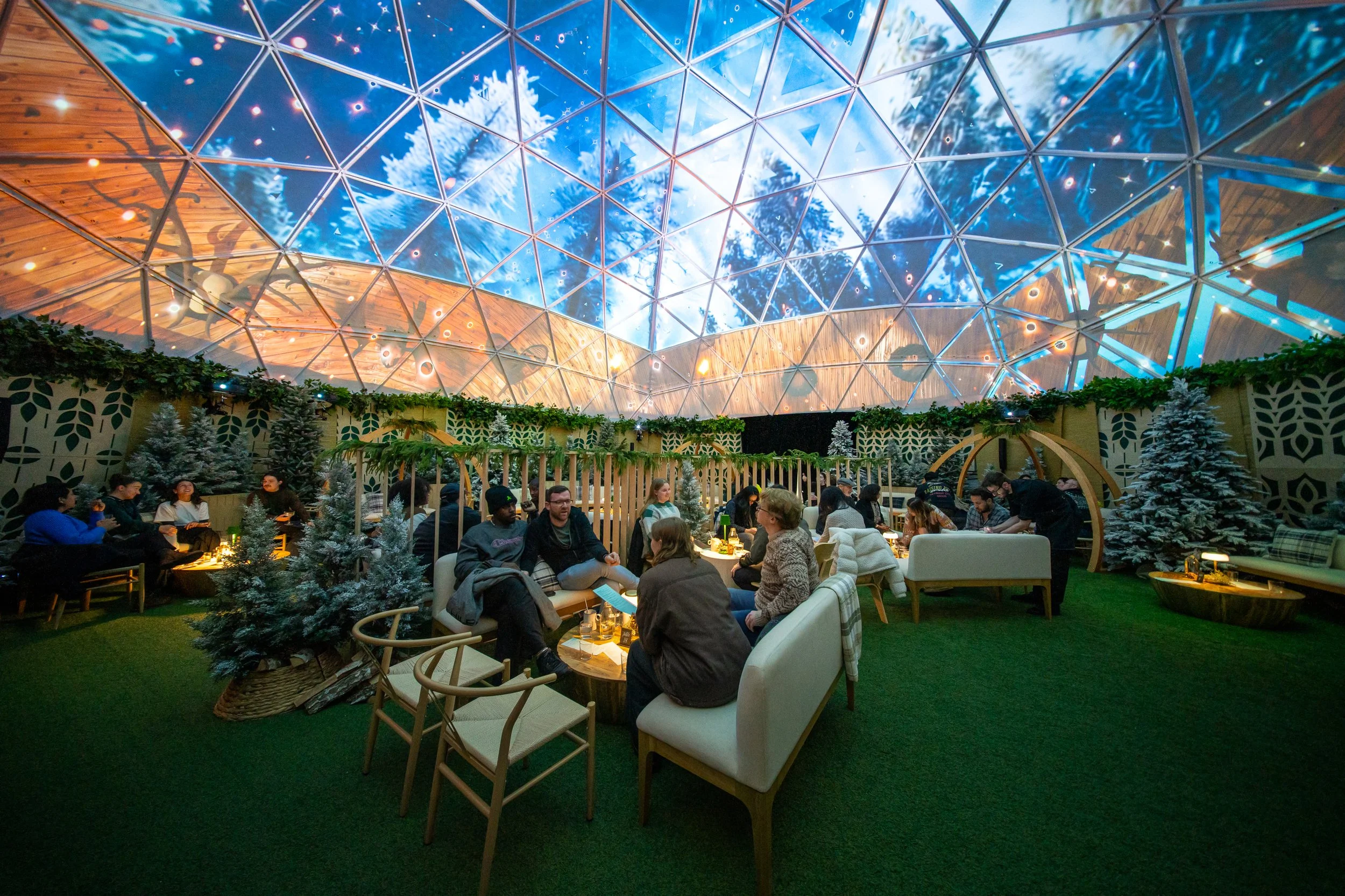 Projection dome by NOVA Light Labs, winter forest mapped across the ceiling above a lounge of guests.