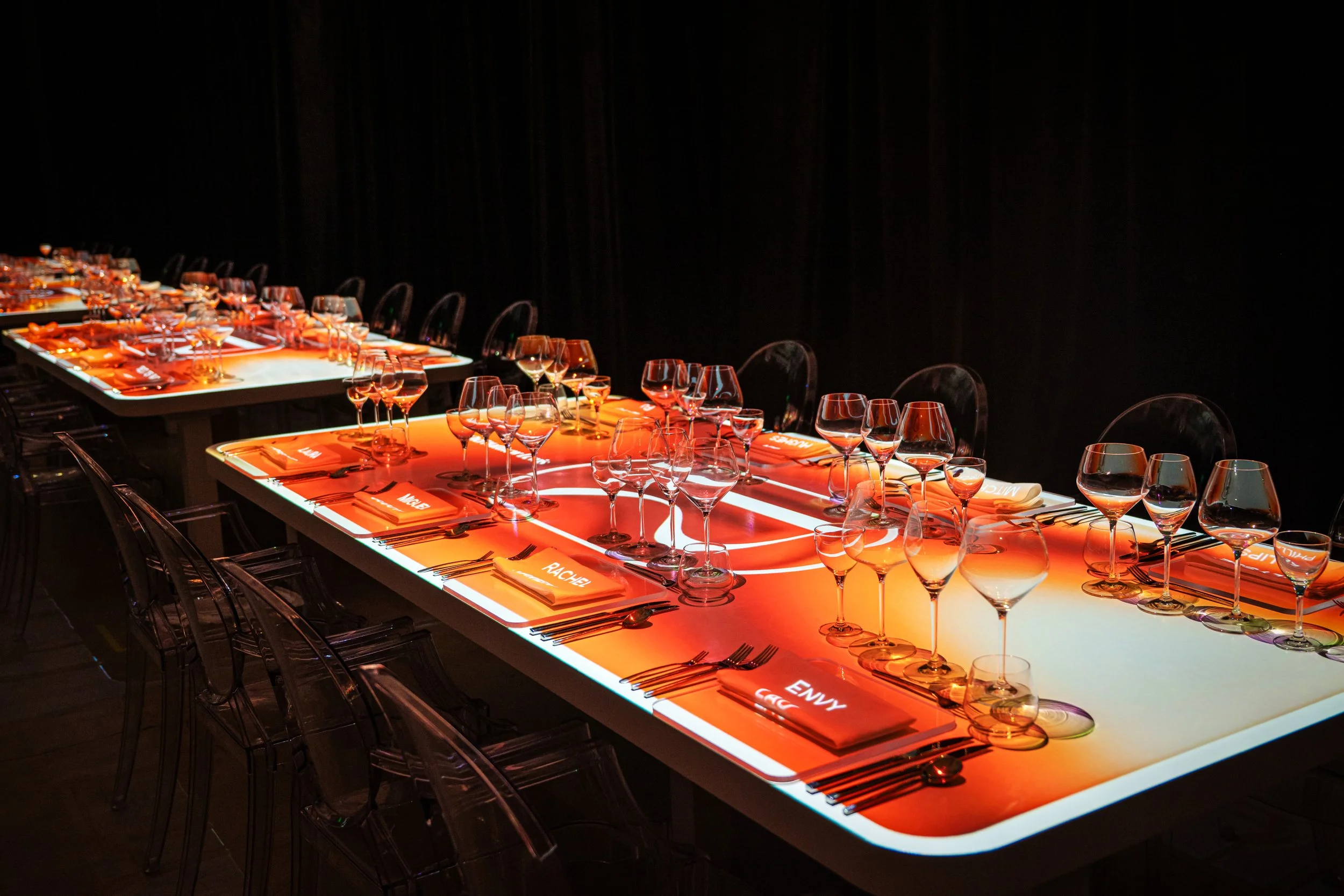 The Radiant Table immersive dining, projection mapped table glows amber with guest names on place cards