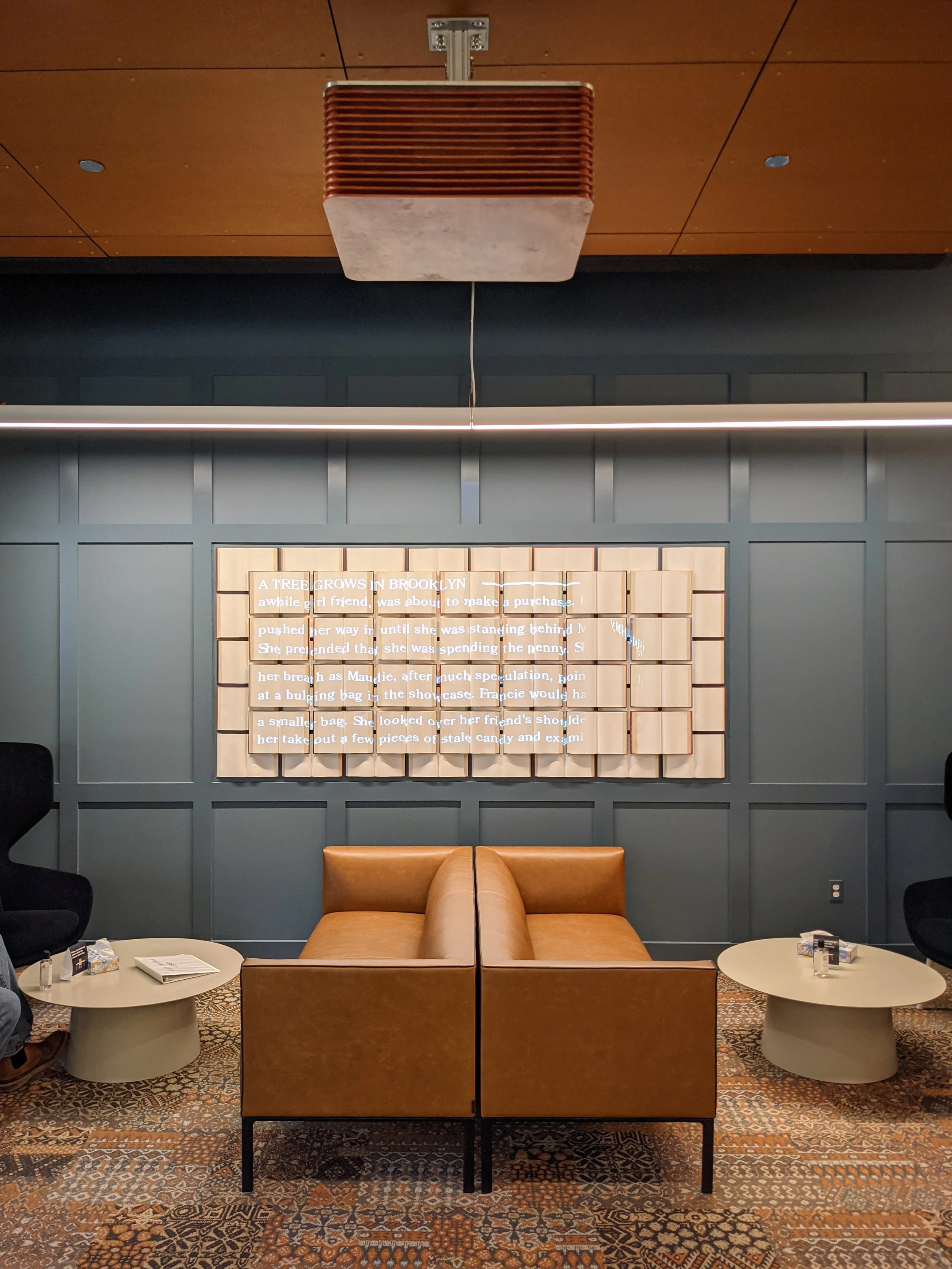 Amazon Seattle headquarters projection mapping, front view of the book sculpture with the ceiling projector housing.