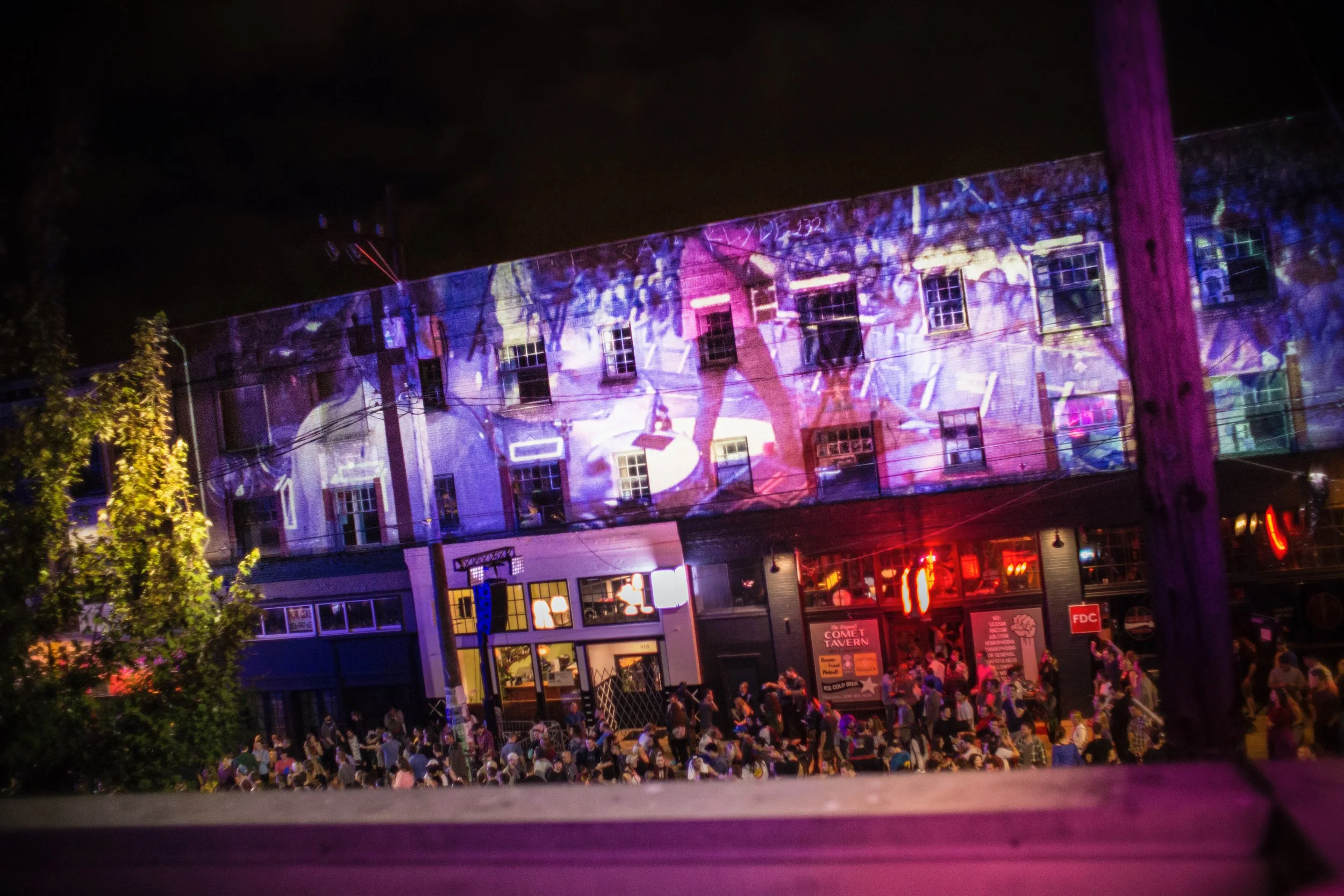 Capitol Hill Block Party projection mapping in Seattle, dancers across a brick facade above the crowd