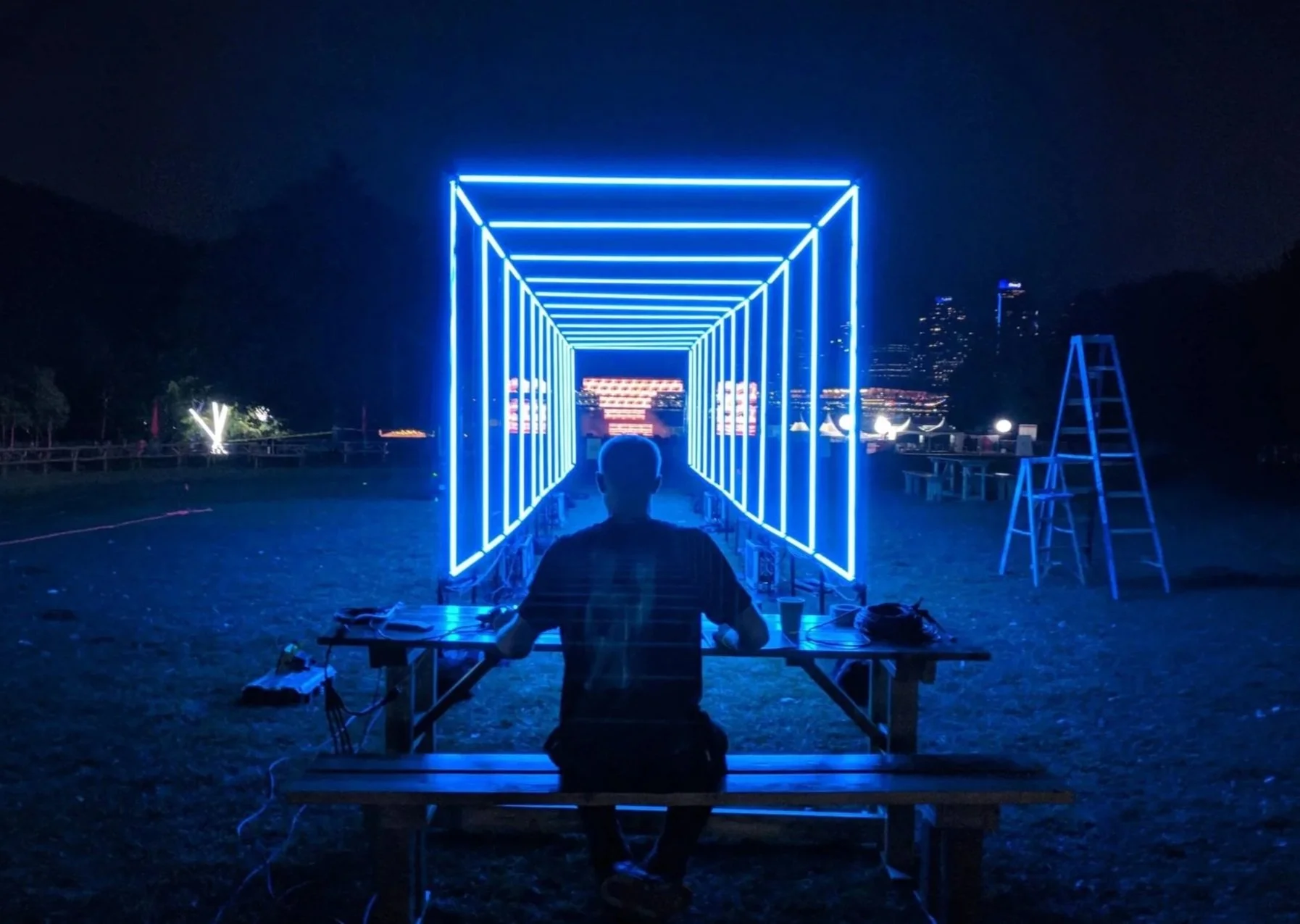 lululemon SeaWheeze LED tunnel custom visuals, silhouette at a table facing the blue lit wireframe