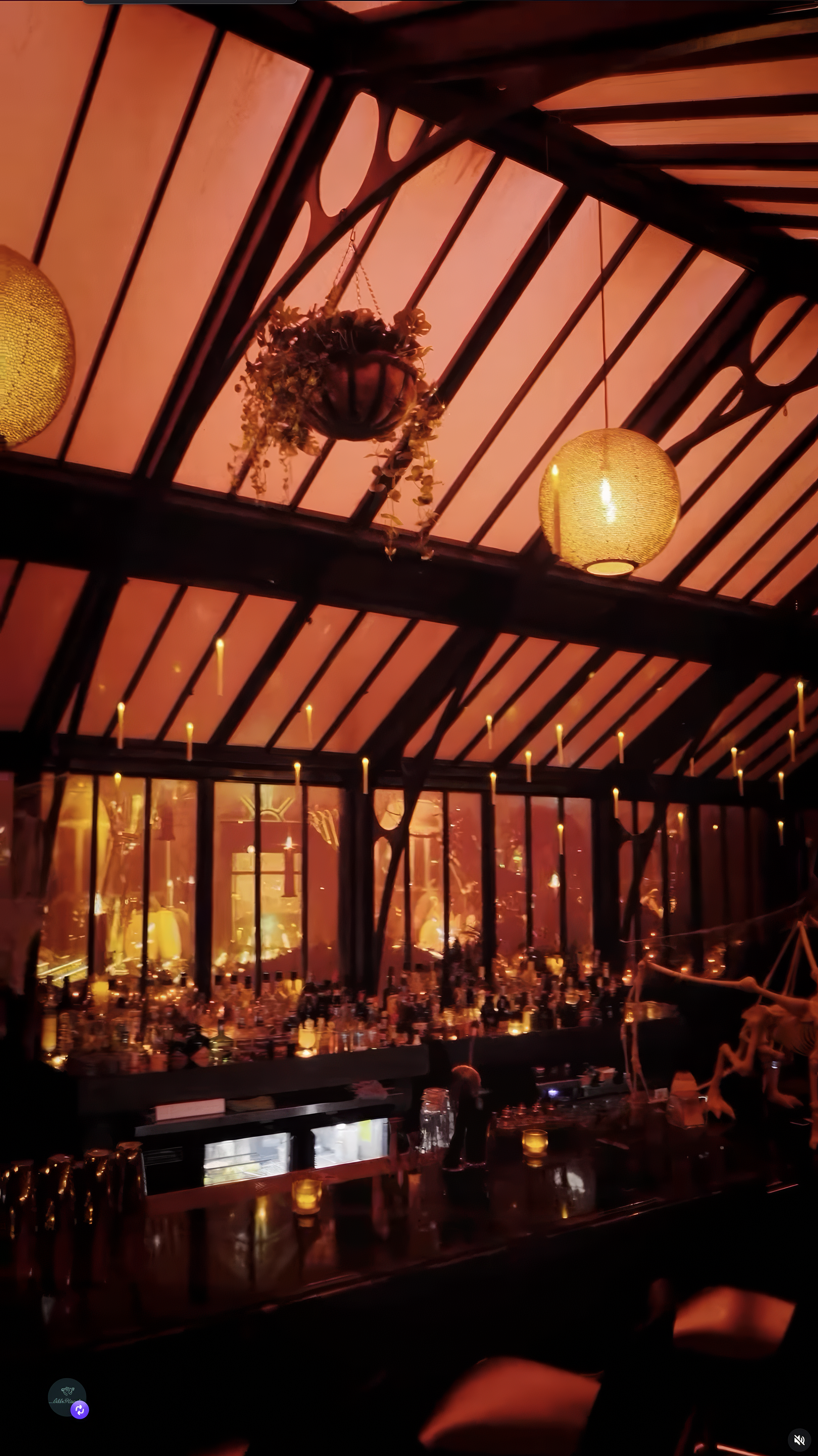 Fall visuals glowing through the windows behind the bar at Idle Hands Phoenix, candles lining the glass roof beams