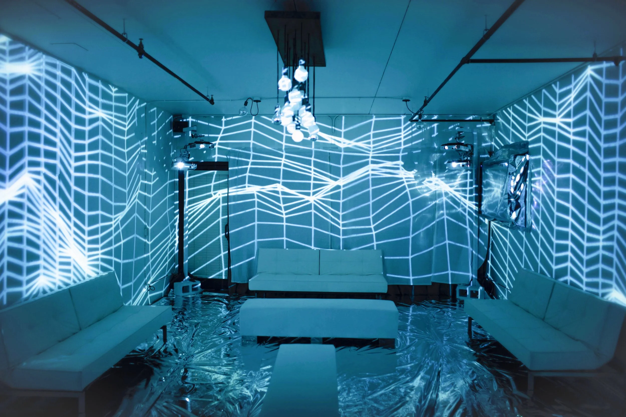 Fremont Foundry immersive projection mapping room, blue topographic line visuals over lounge seating and Mylar floor