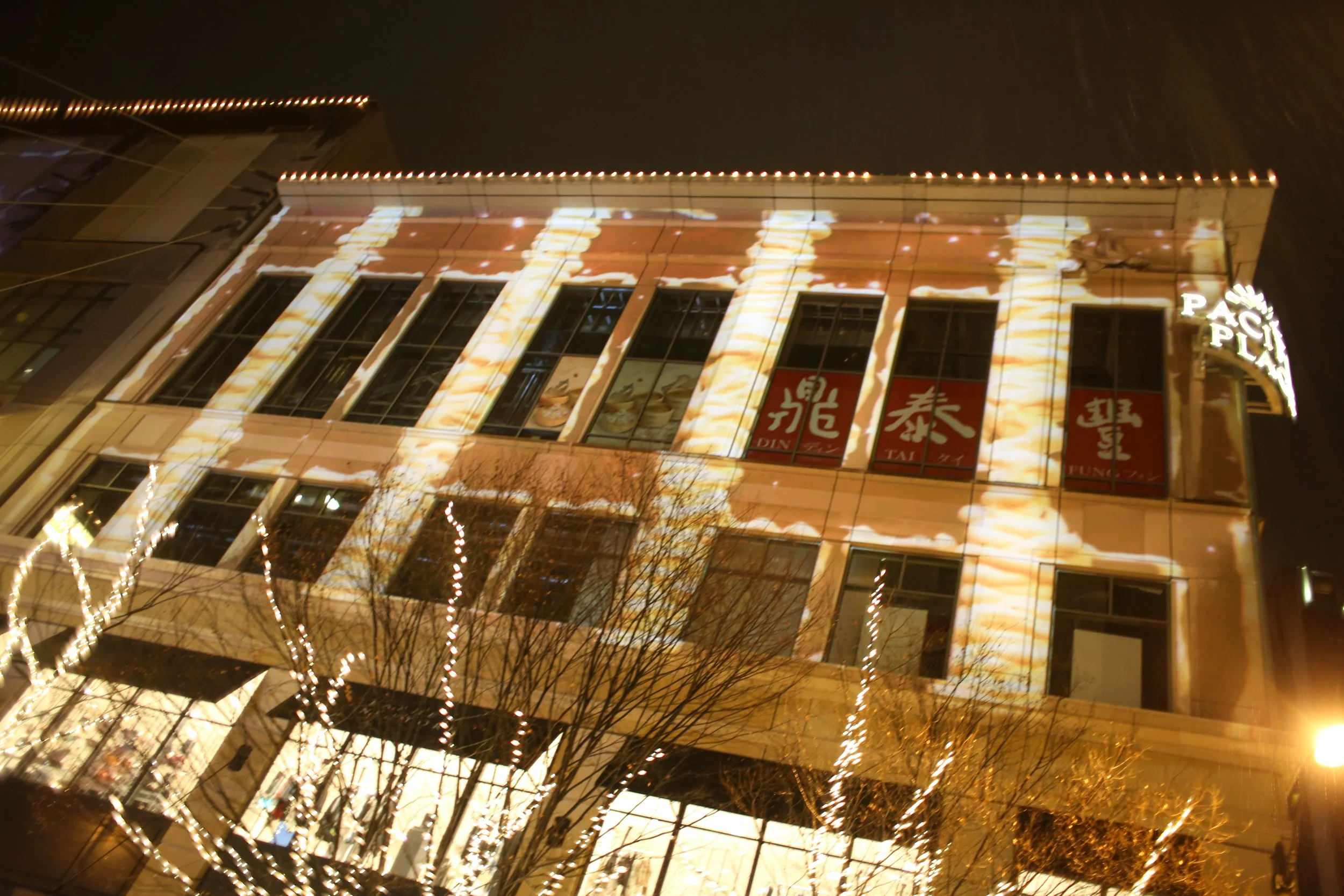 Pacific Place holiday projection mapping, downtown Seattle, warm cascading light across the facade windows