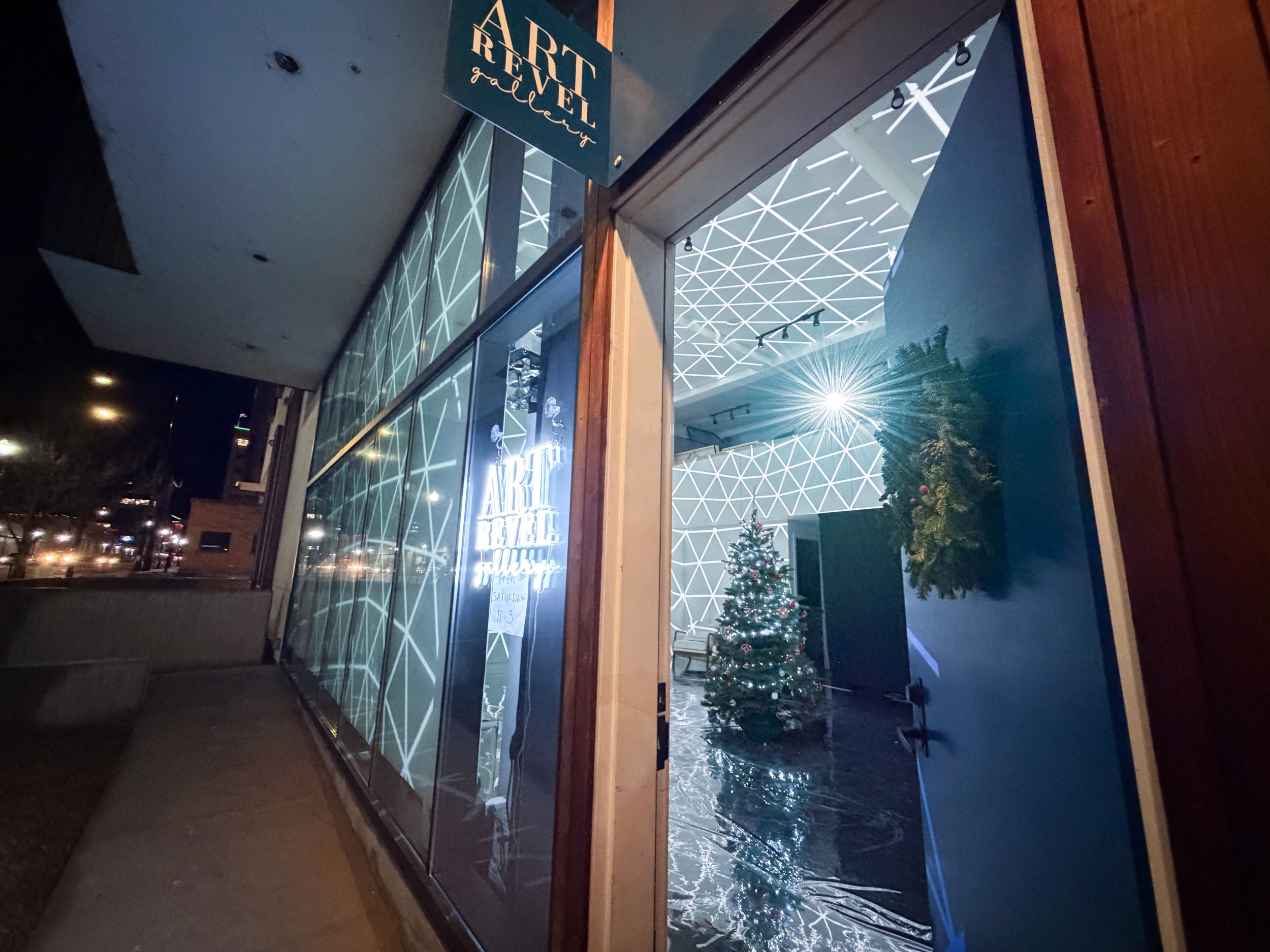 Polaris projection mapping at Art Revel Gallery Boise, storefront view of white geometric webbing and a lit tree.