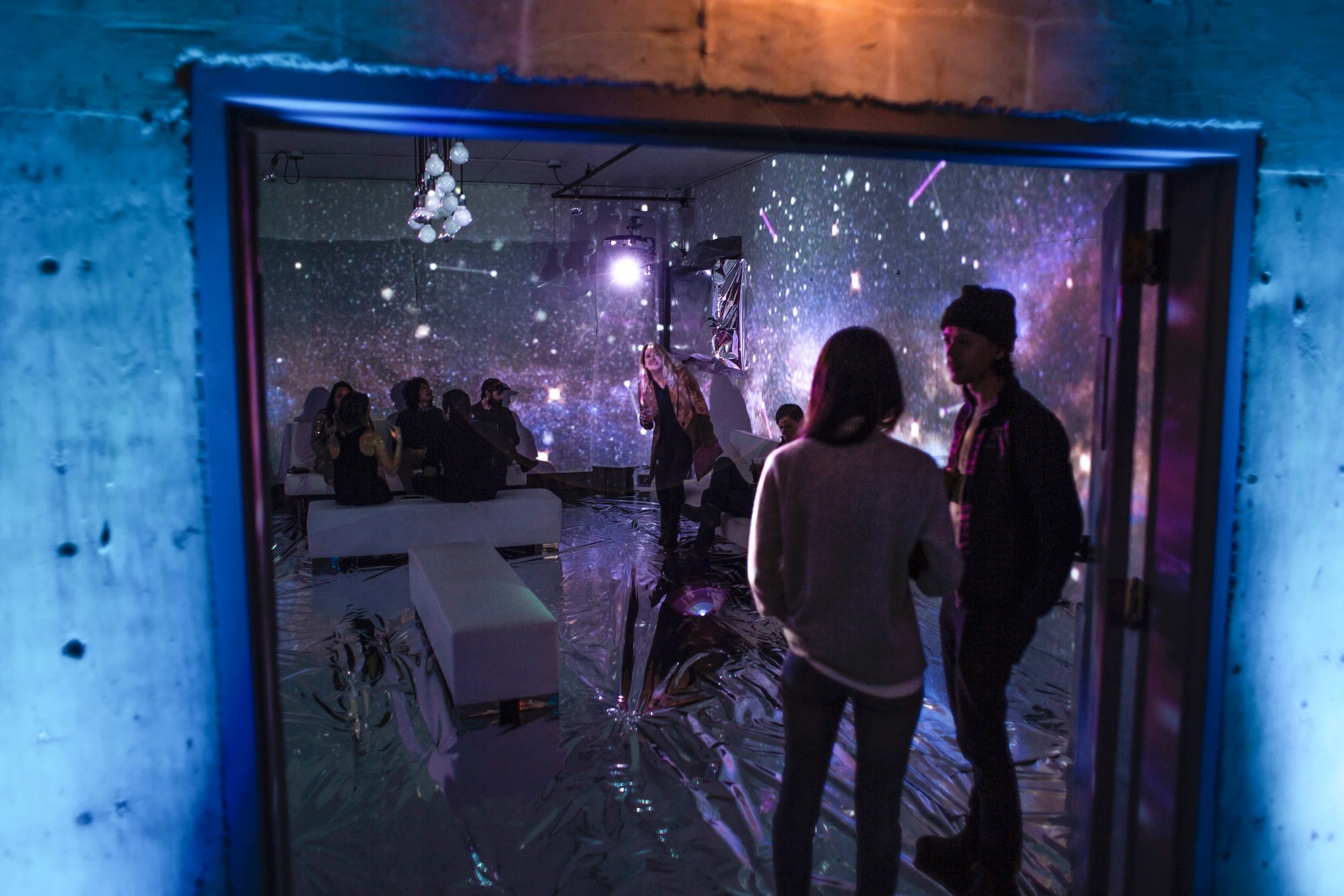 Fremont Foundry immersive room, guests in the doorway framed by a cosmic starfield across walls and Mylar floor