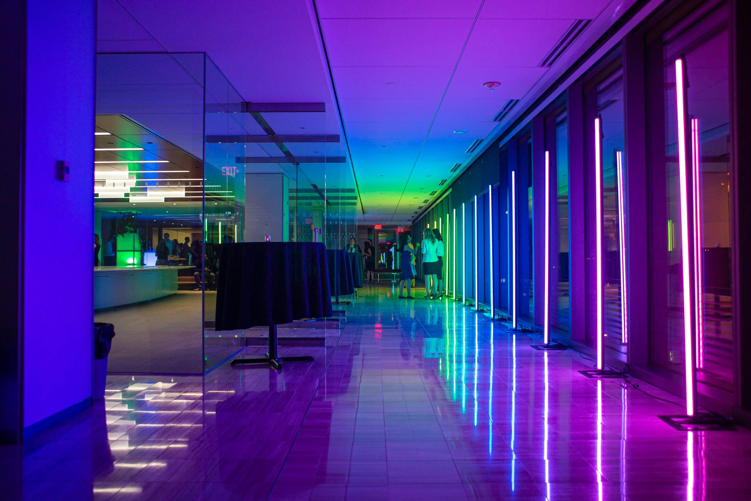 Vertical LED bars line a glass corridor at Holland & Knight in Washington, DC, reflections doubling on the marble floor.