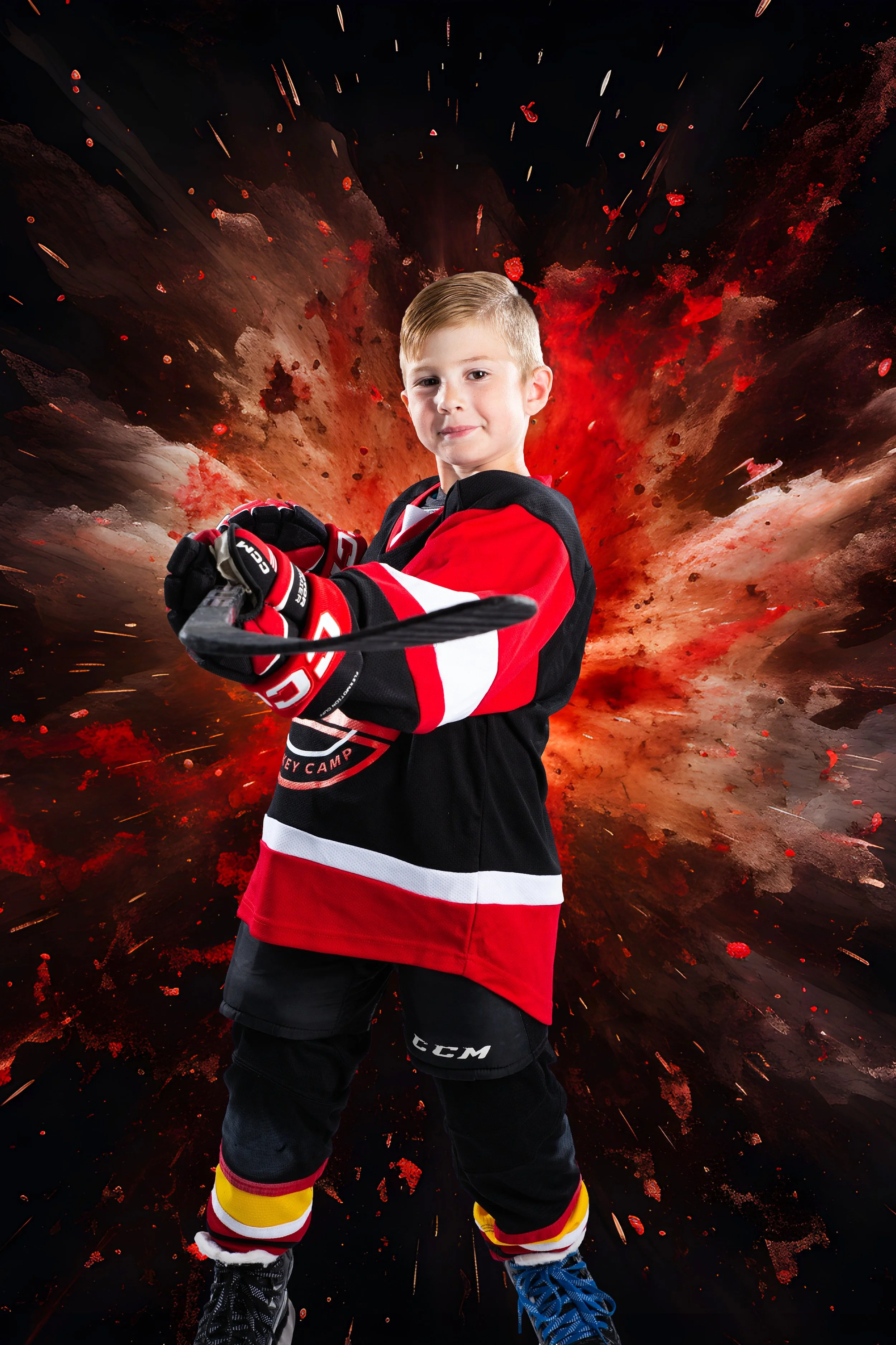A young boy in a hockey uniform standing with his arms crossed in front of a fiery, explosion-like background.