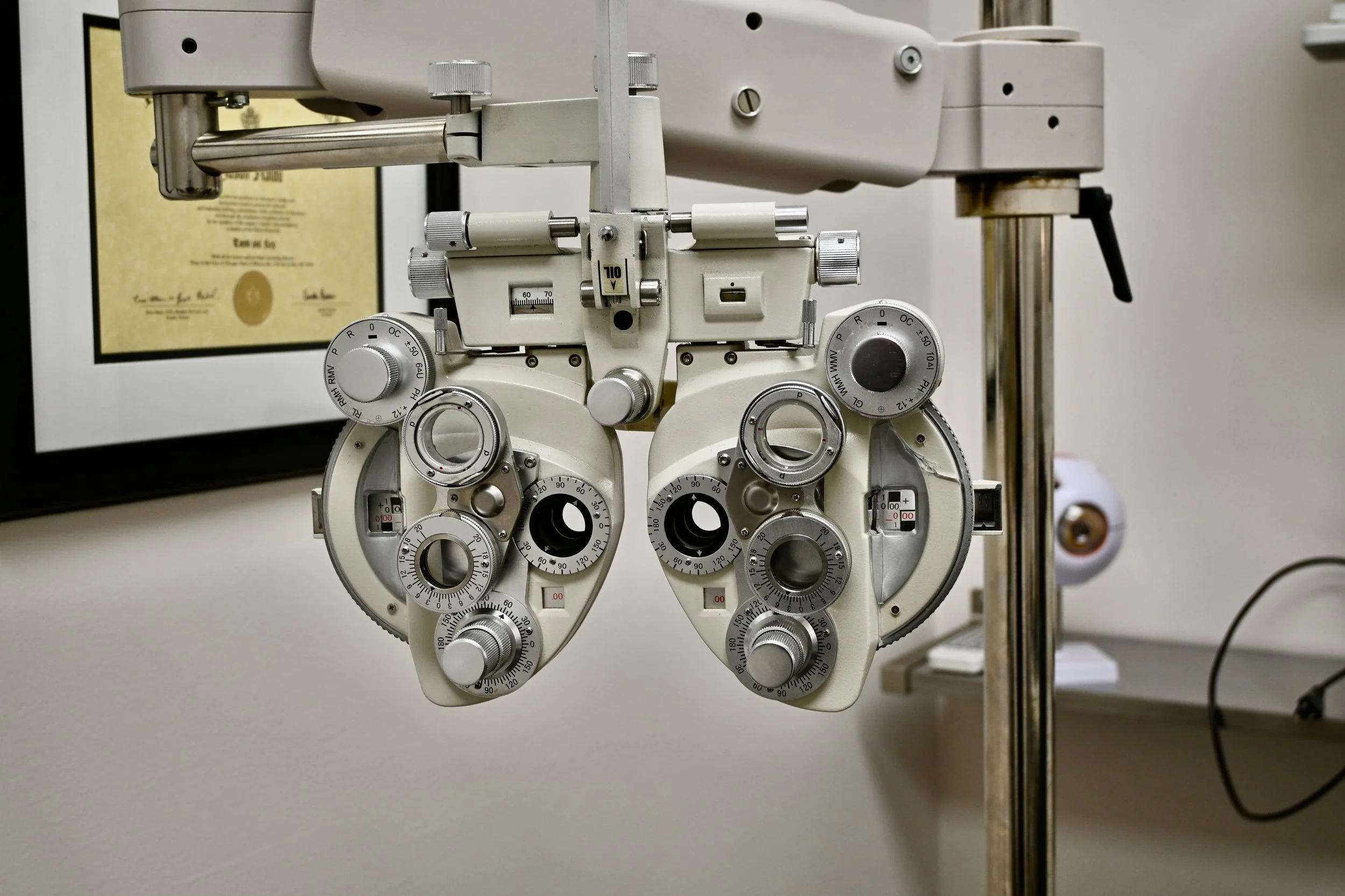An ophthalmology slit lamp microscope used for eye examinations, showing multiple dials and adjustable components.