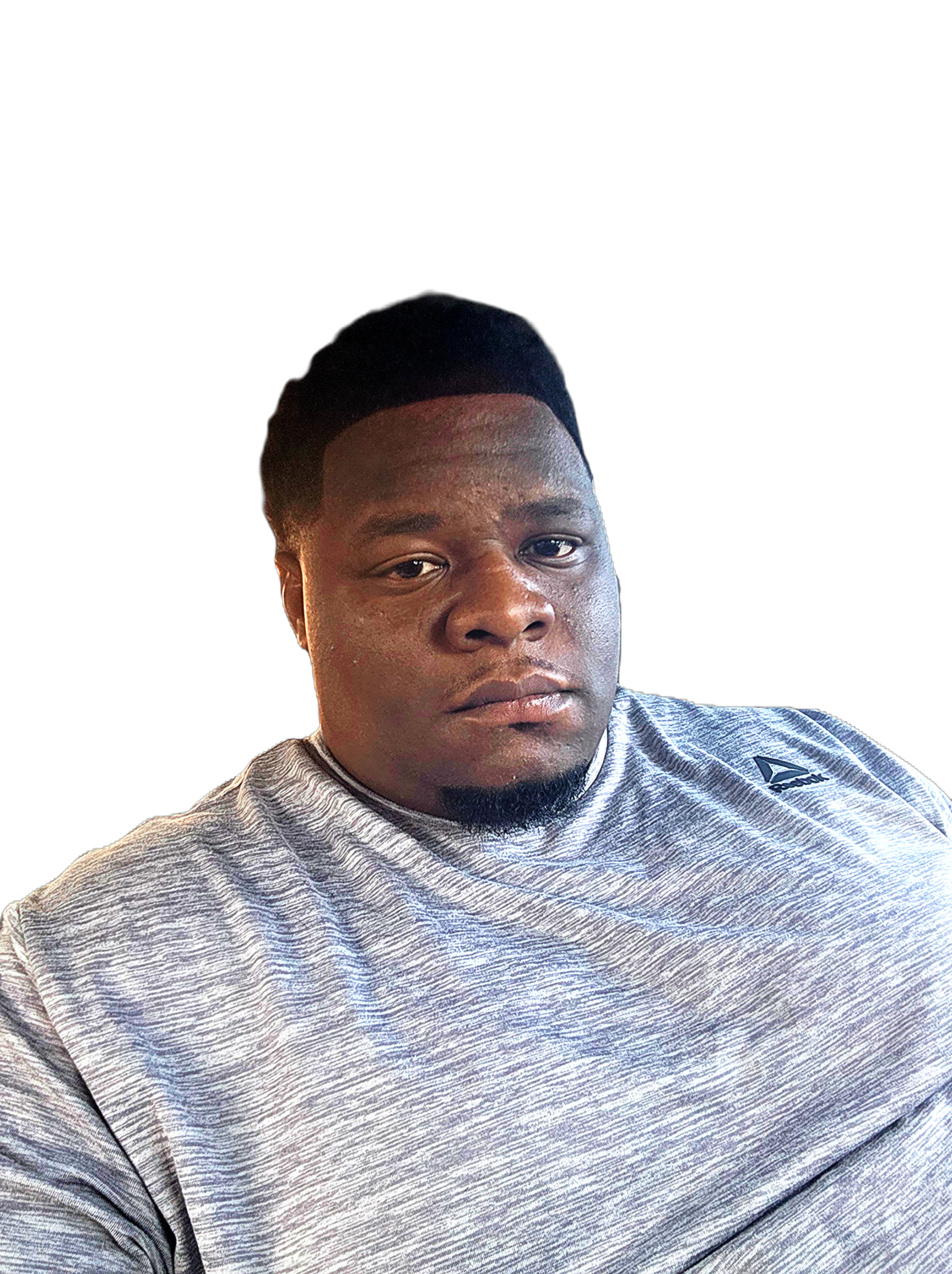 A young man with dark hair wearing a gray athletic shirt, posing against a plain black background.
