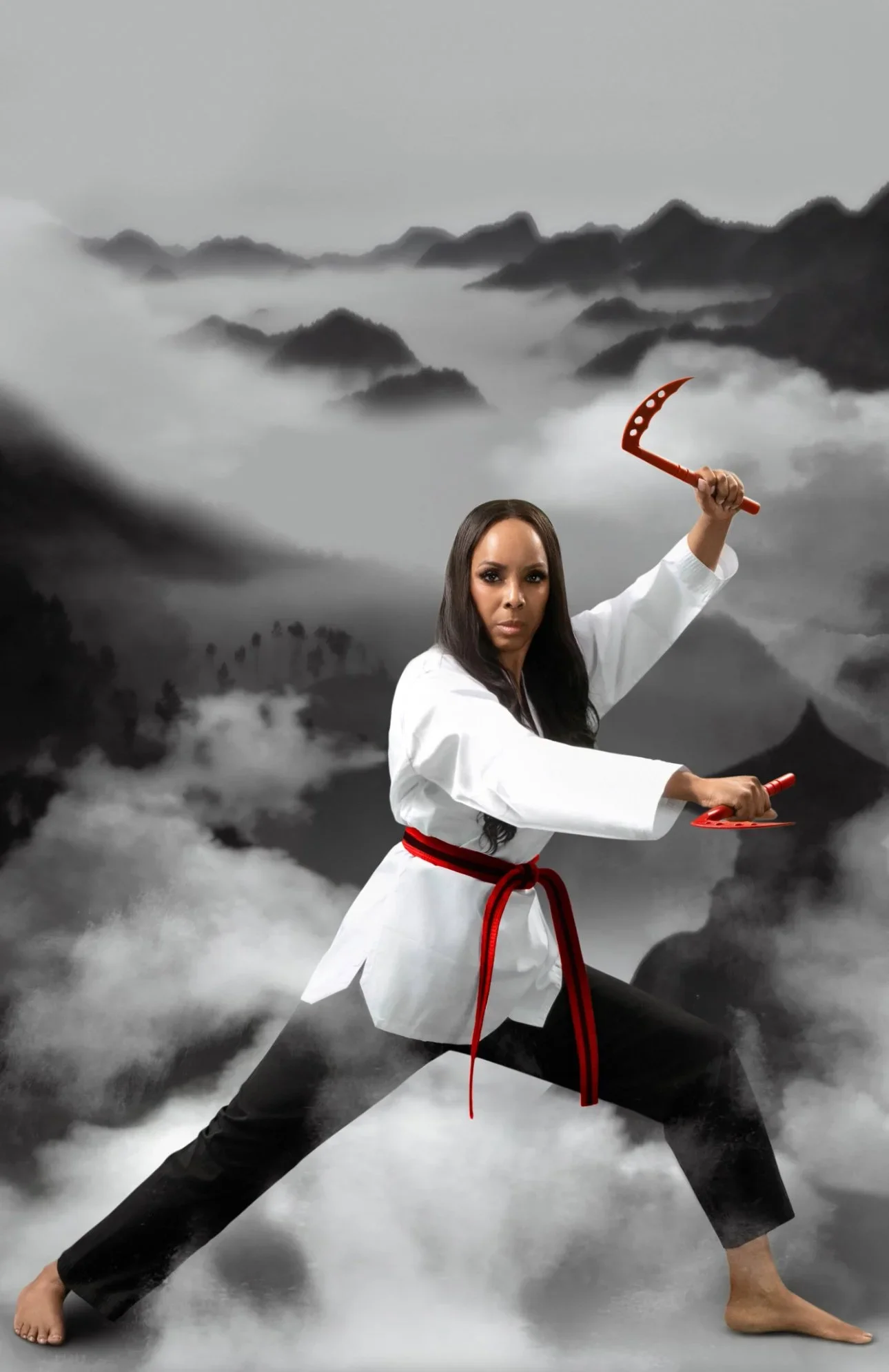 A woman in a martial arts uniform with a red belt, holding weapons in a fighting stance, against a black and white mountain landscape background.