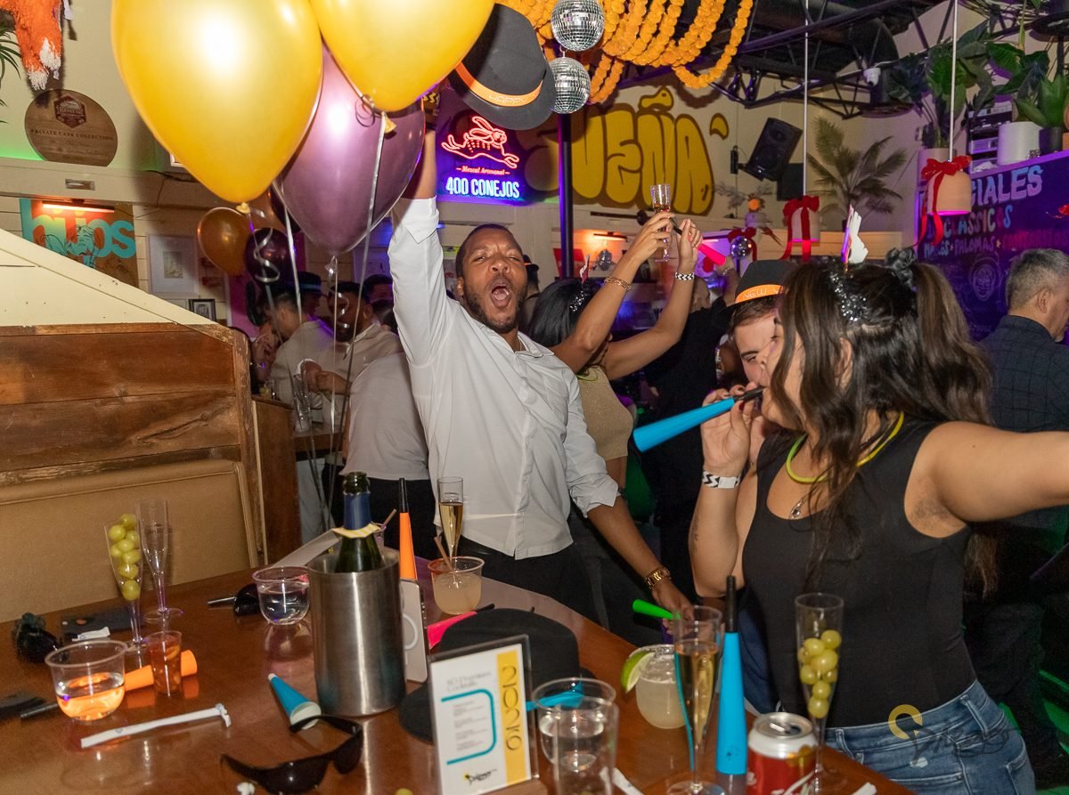 A guest celebrating with balloons and noisemakers at a holiday party at Diego in West Town