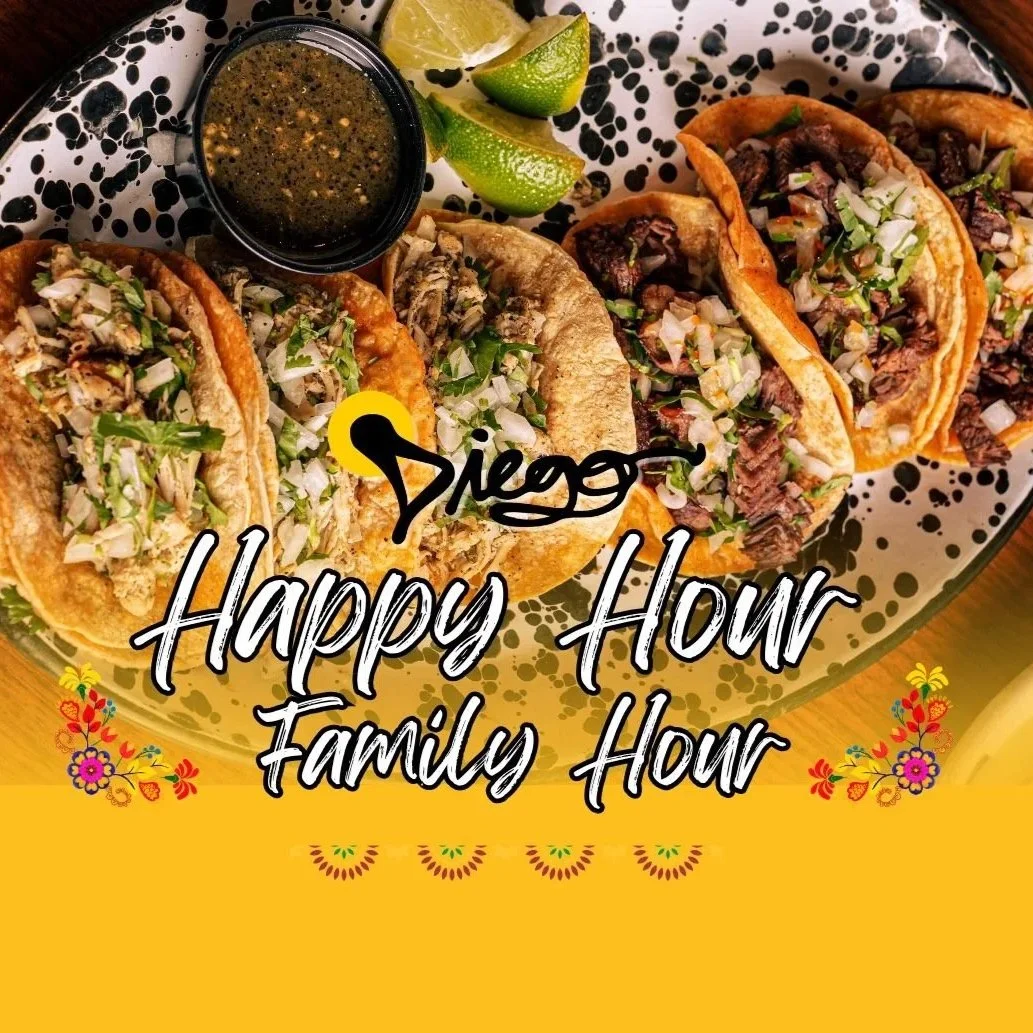 Three glasses of a pink cocktail with ice and black straws, two glasses of clear liquid with ice, a small jar with a plant, on a wooden table in a warmly lit indoor setting.